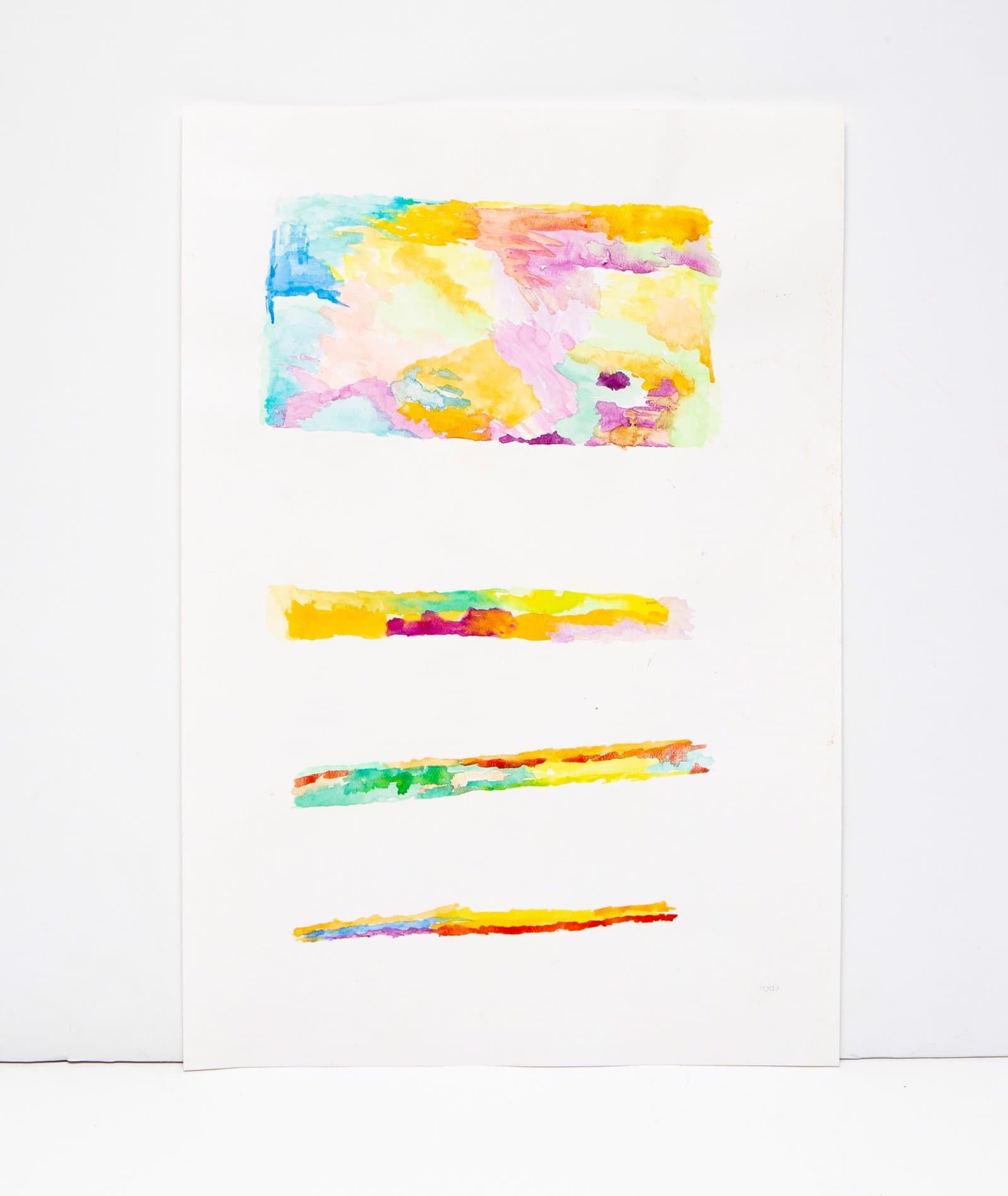Abstract watercolor painting with large rectangular form and three horizontal bands in bright yellows, pinks, blues, and oranges on white paper.