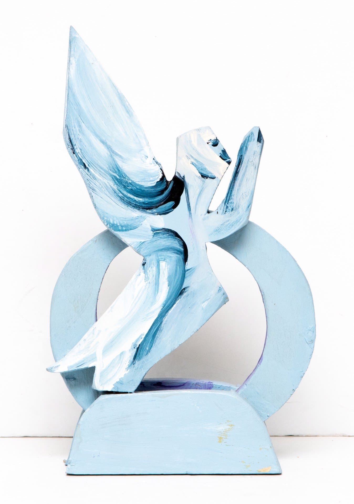 Abstract wooden sculpture with blue and white paint, featuring angular forms and a circular element