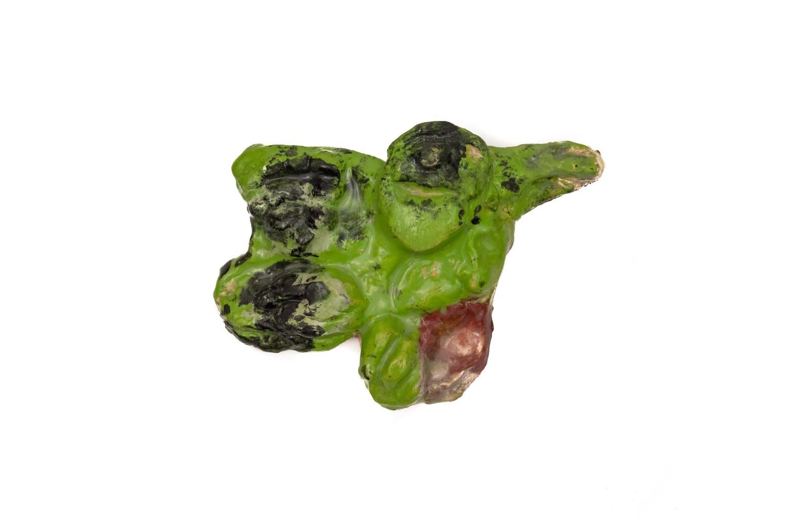 Ceramic sculpture with organic green form and dark charred areas, mixed with reddish elements
