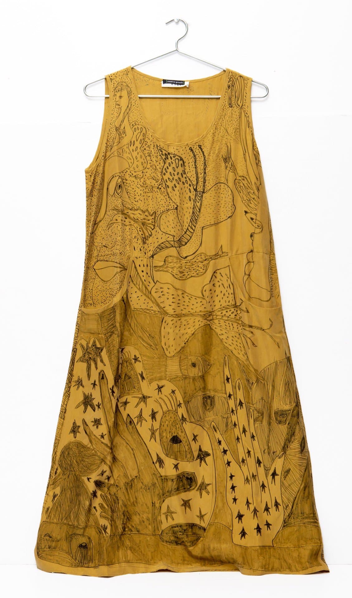 Yellow sleeveless dress with black ink drawings of snakes, animals, and geometric patterns throughout the fabric.