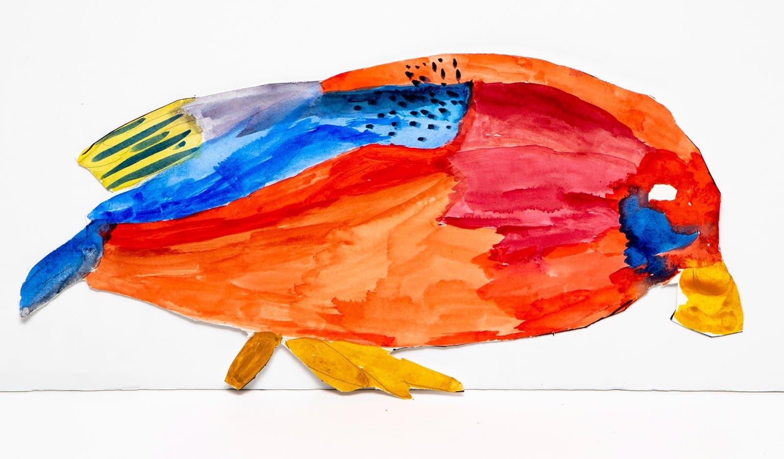 Watercolor cutout of a fish-like form in bright orange, red, blue, and yellow on white paper with distinctive fins.