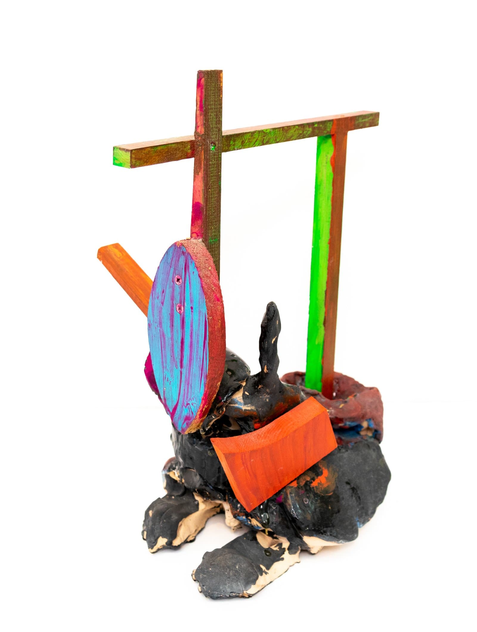 Mixed-media sculpture combining painted wood pieces and ceramic base in black, orange, blue, green, and red.