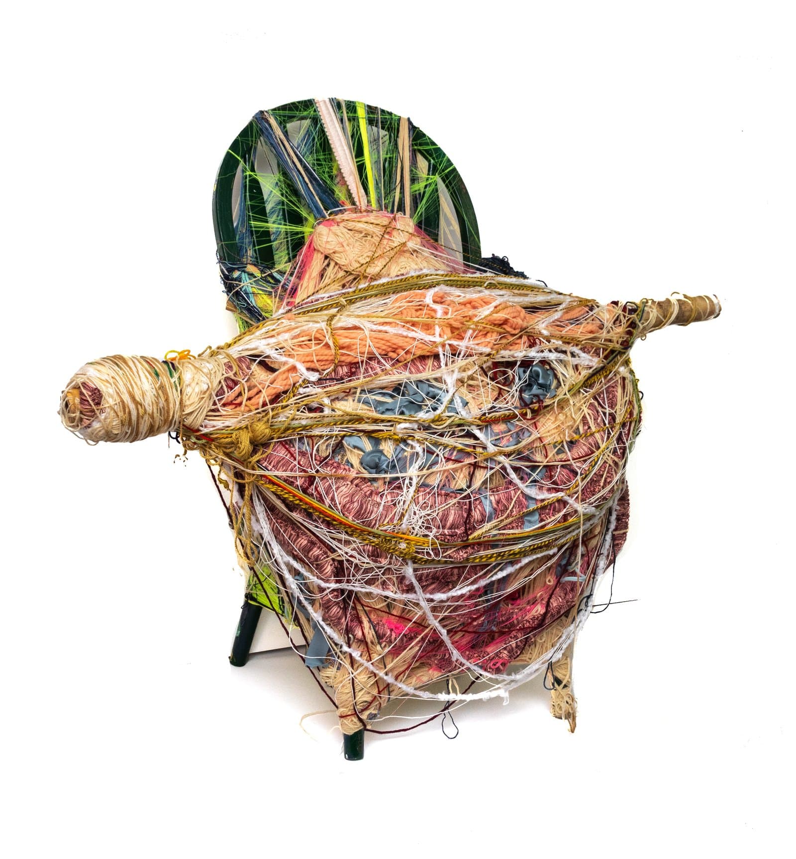 Mixed media sculpture: a chair densely wrapped in multicolored yarn, fabric, and fiber with a rod extending horizontally.