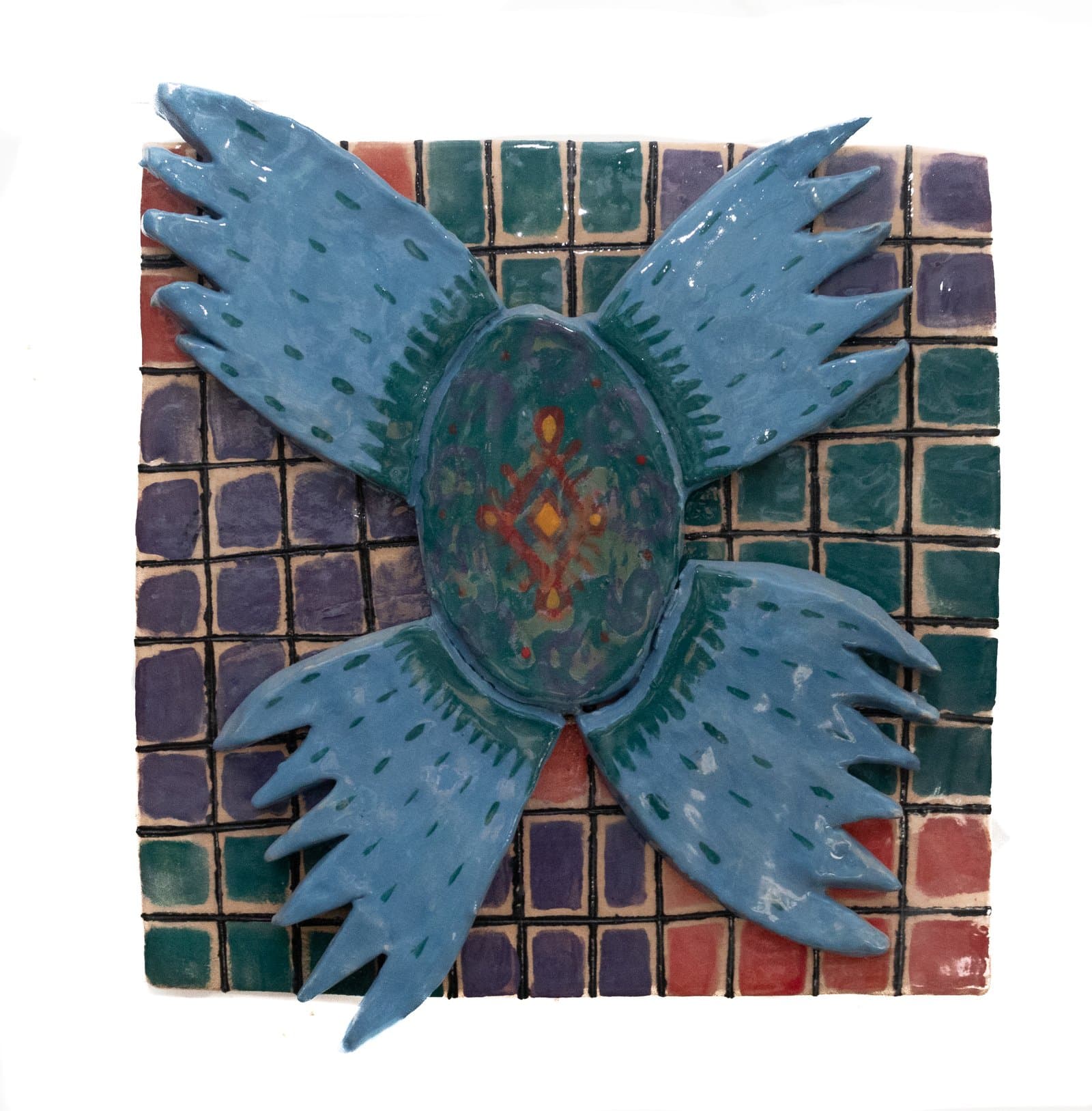 Ceramic relief tile panel featuring a blue winged bird form over a multicolored grid background with a decorated oval center.