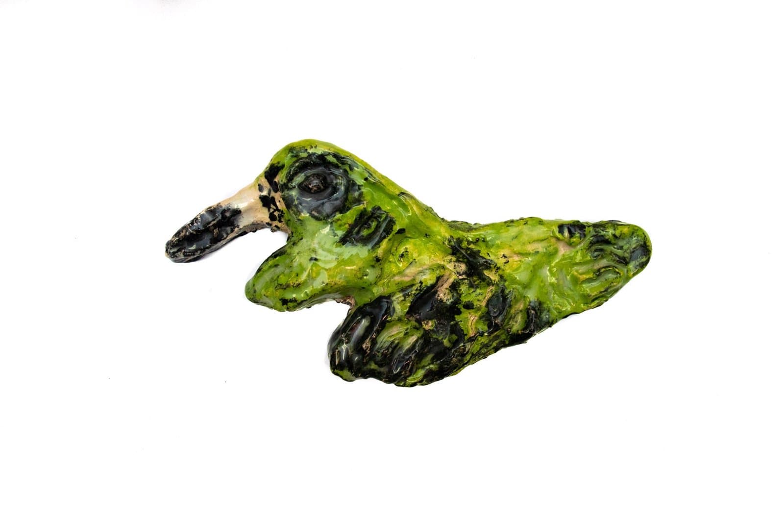 Ceramic sculpture of green bird-like form with black details and mottled surface texture