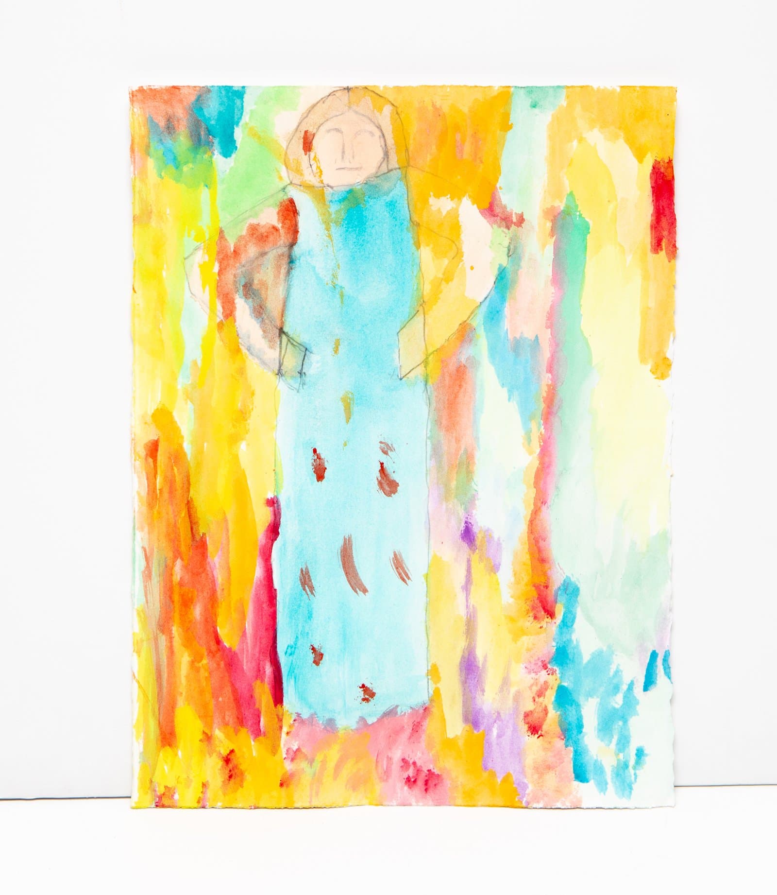 Watercolor painting of a standing figure in a light blue robe surrounded by vivid washes of yellow, orange, pink, and teal.
