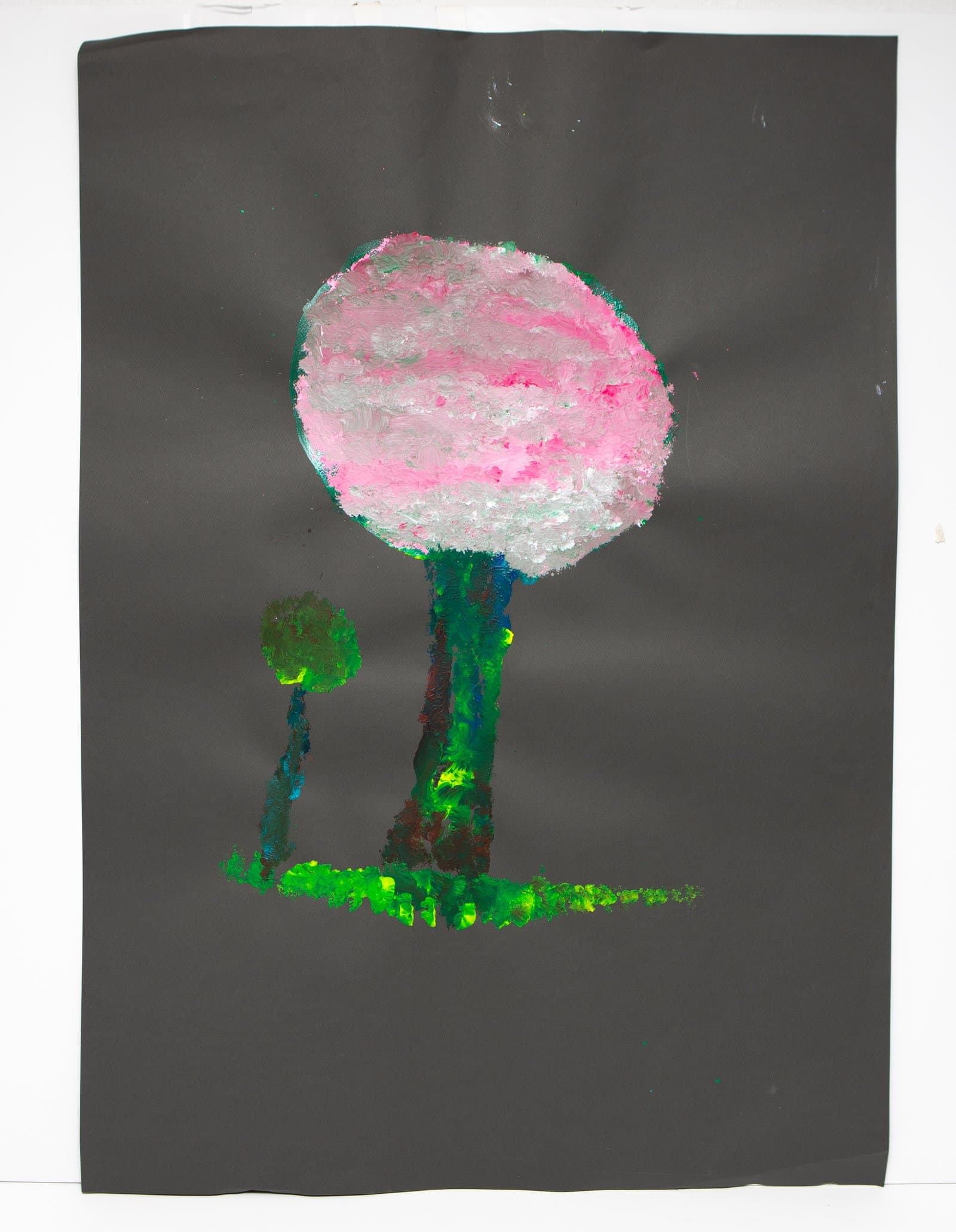 Acrylic painting of two trees with round canopies on dark gray paper; large pink tree beside a smaller olive green one.