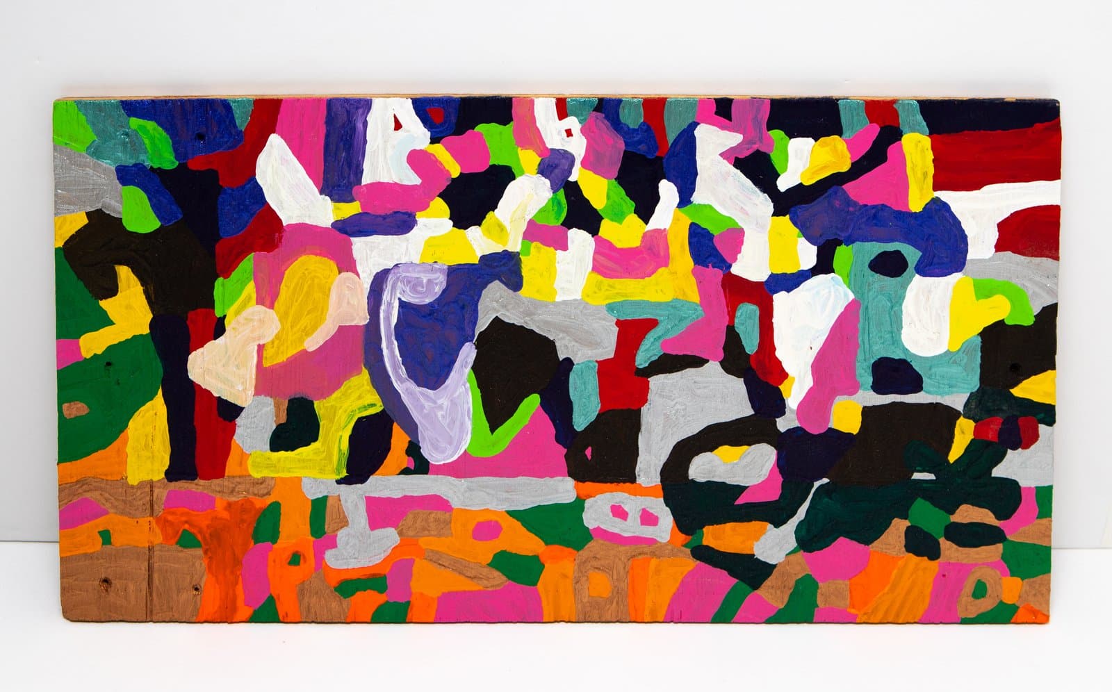 Abstract acrylic painting on wood with densely packed, irregular shapes in vivid multicolors across the entire surface.