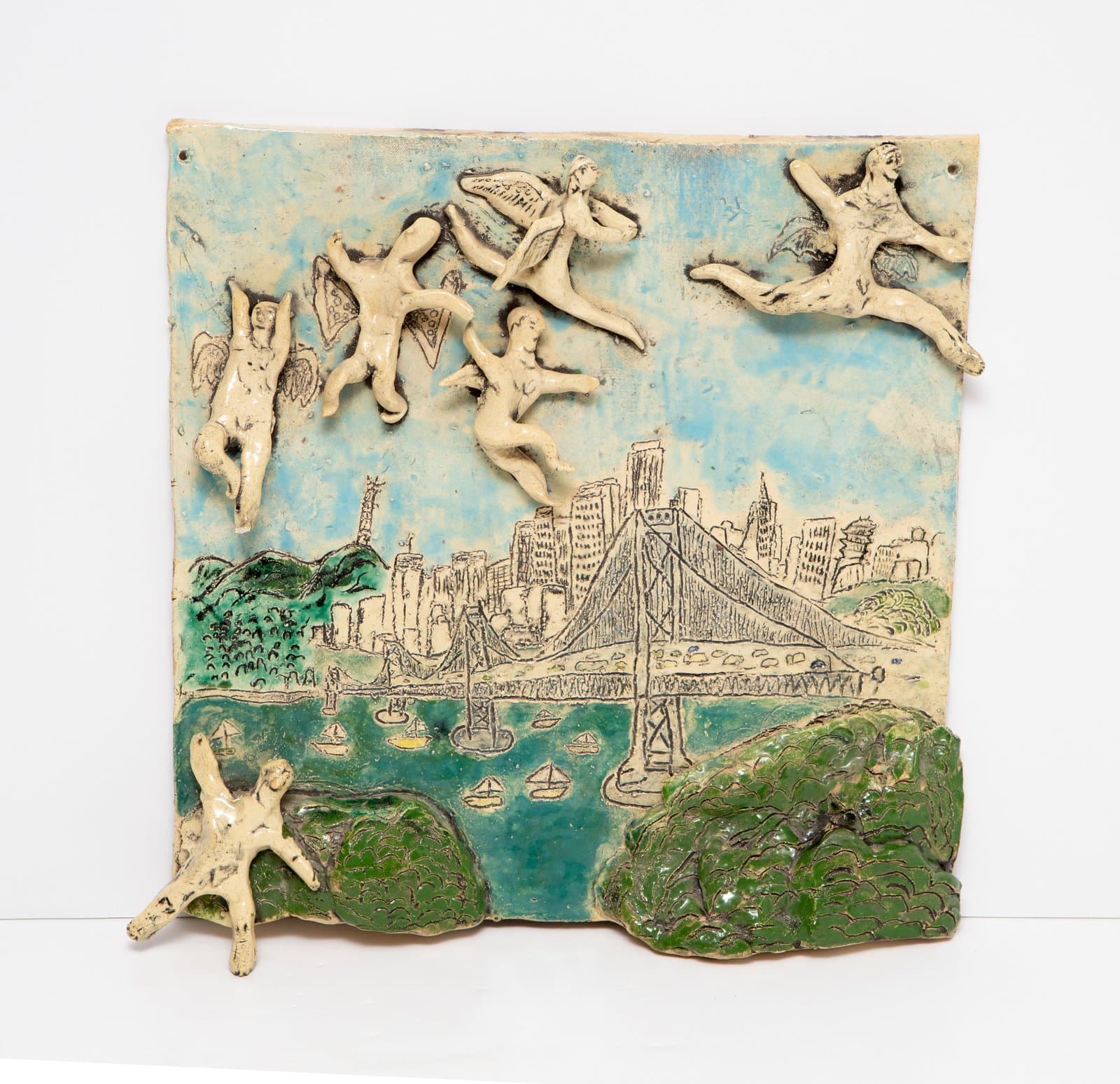 Glazed ceramic relief tile depicting flying angel figures above a cityscape with bridge, water, and trees in blue and green.