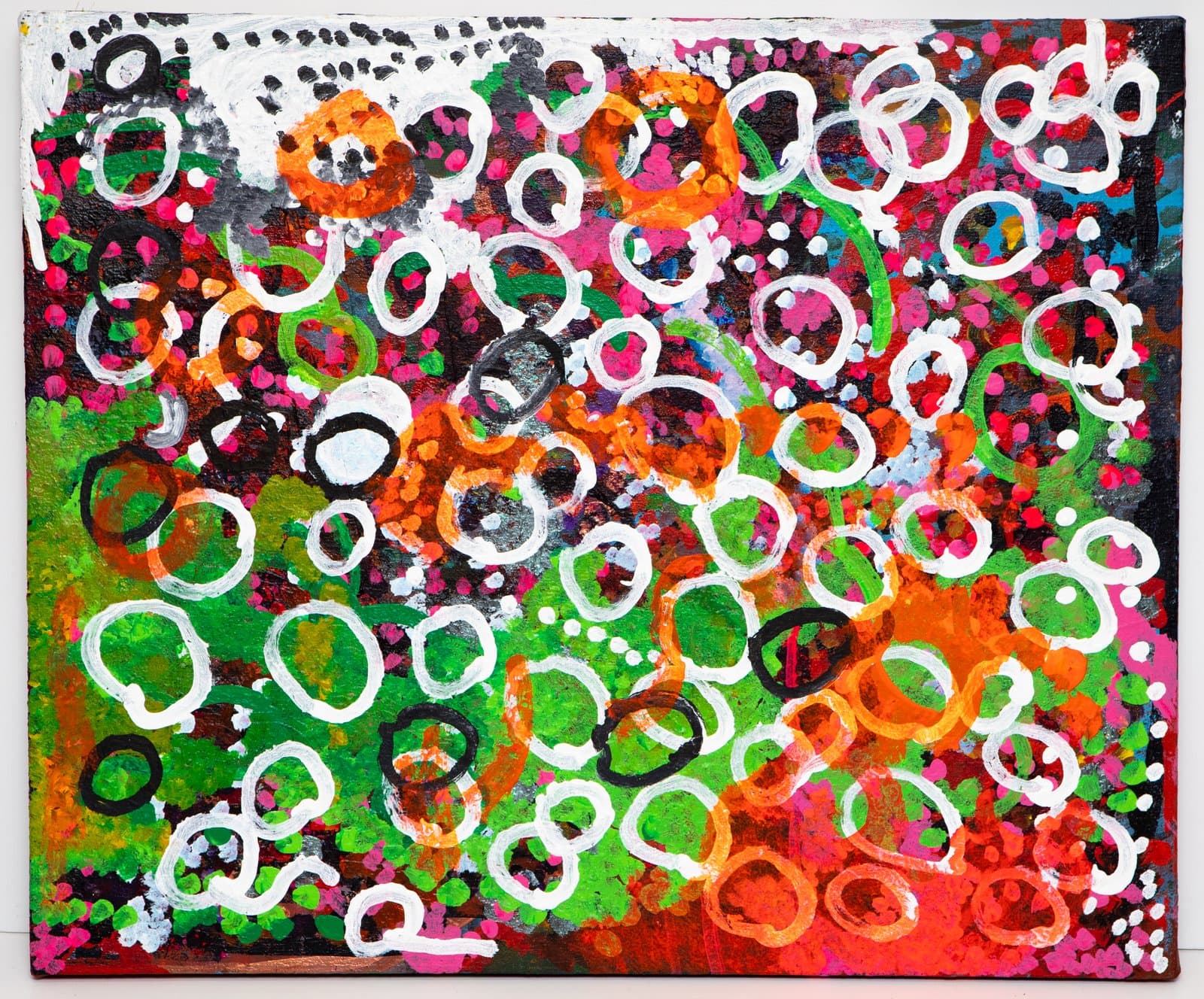 Abstract acrylic painting densely packed with overlapping oval rings in white, orange, and black on a vivid green, pink, and orange background.