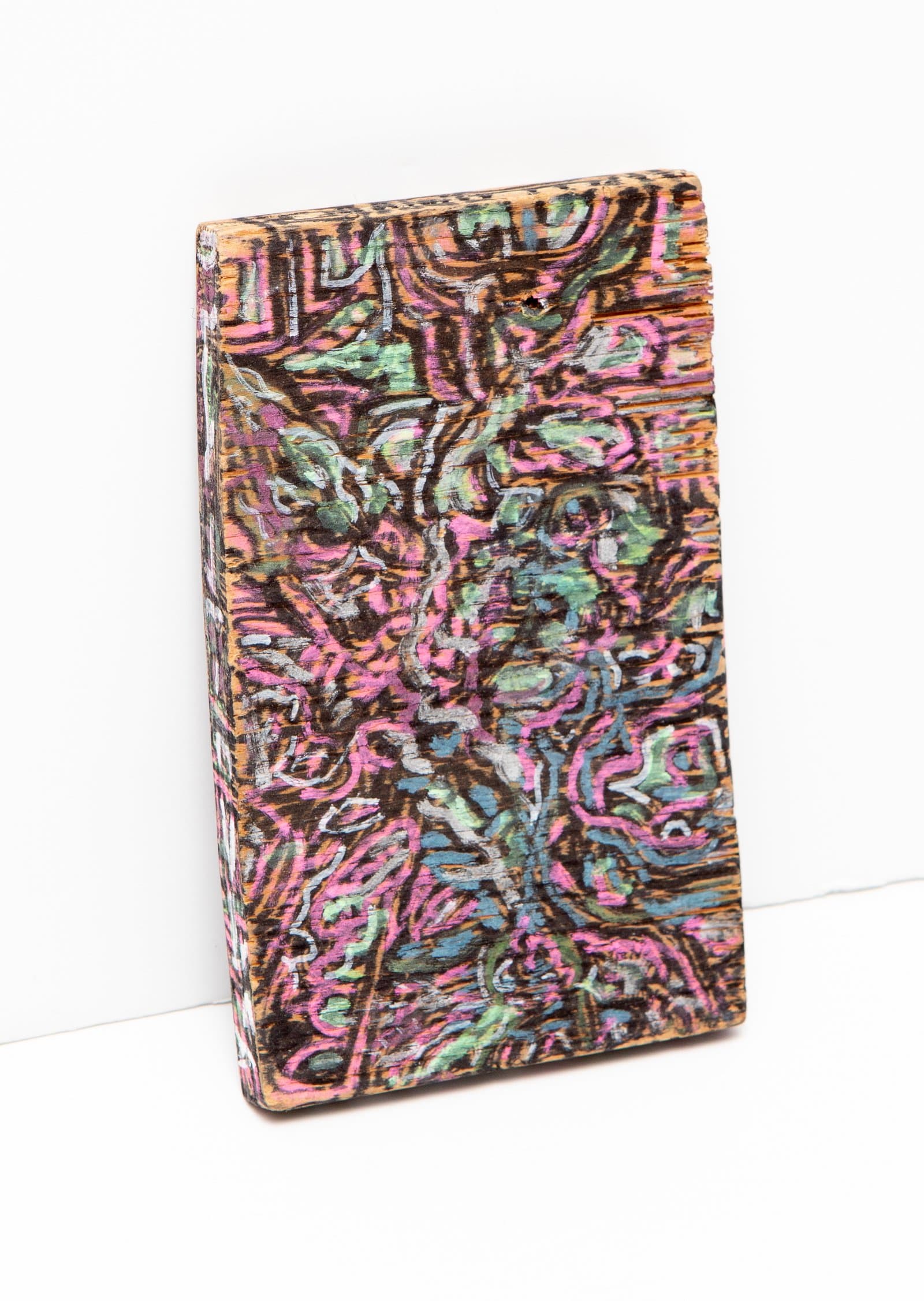 Small rectangular wood block painted with dense, swirling abstract forms in pink, green, blue, and black acrylic.
