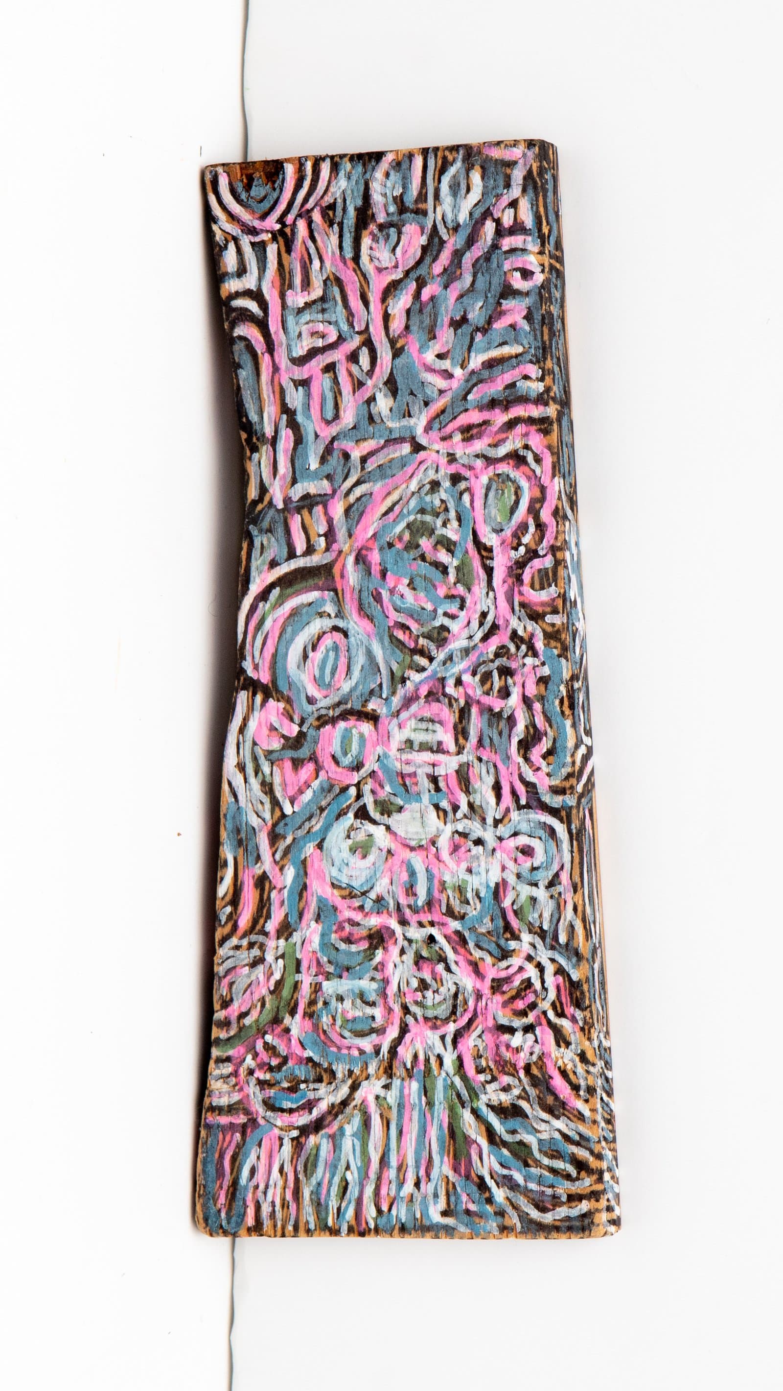 Abstract acrylic painting on a narrow wood plank with dense looping lines in pink, blue, white, and green on dark ground.