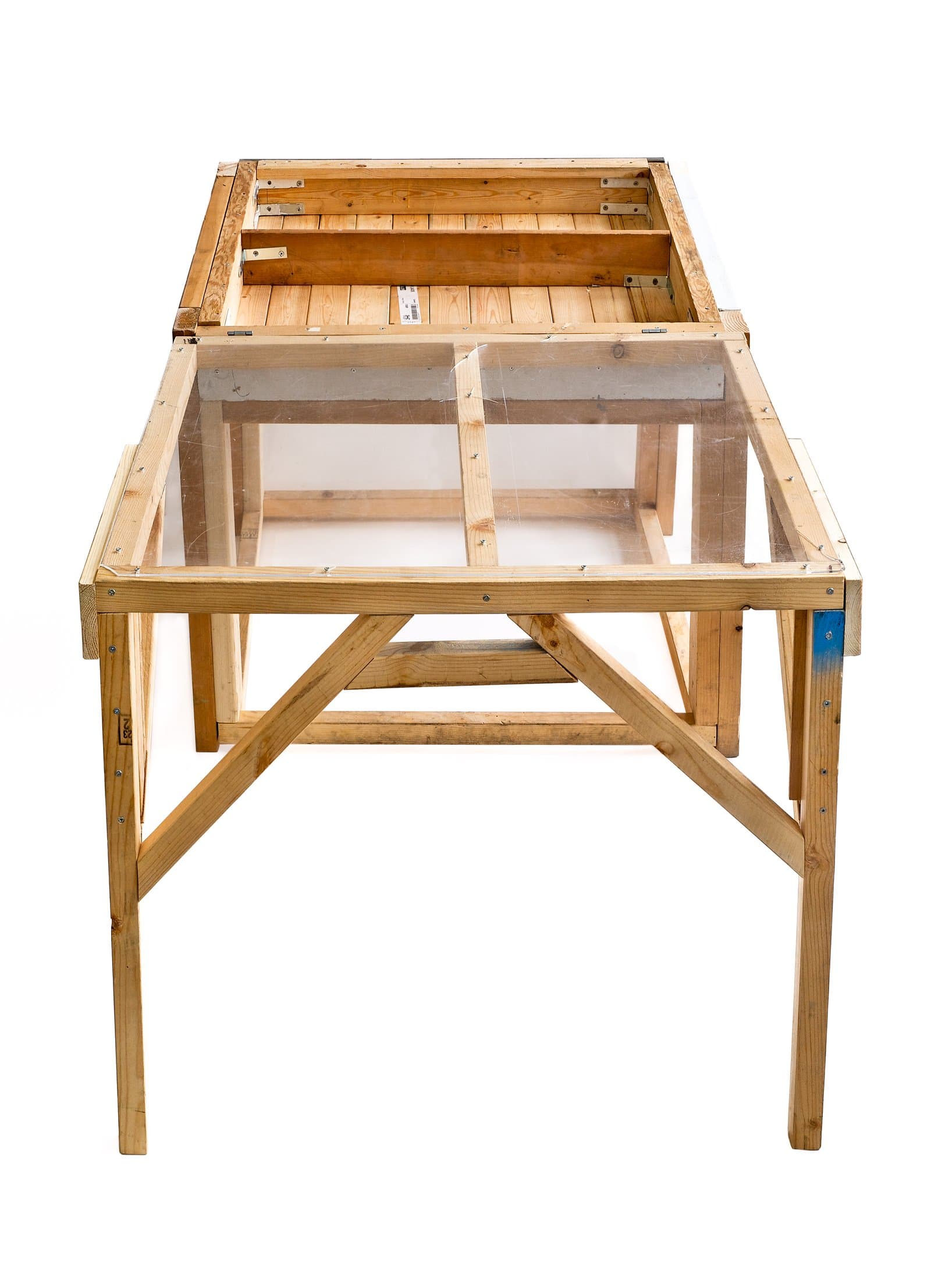 Rectangular wood and acrylic sculpture resembling a table or display case with an open frame structure and slatted top panel.