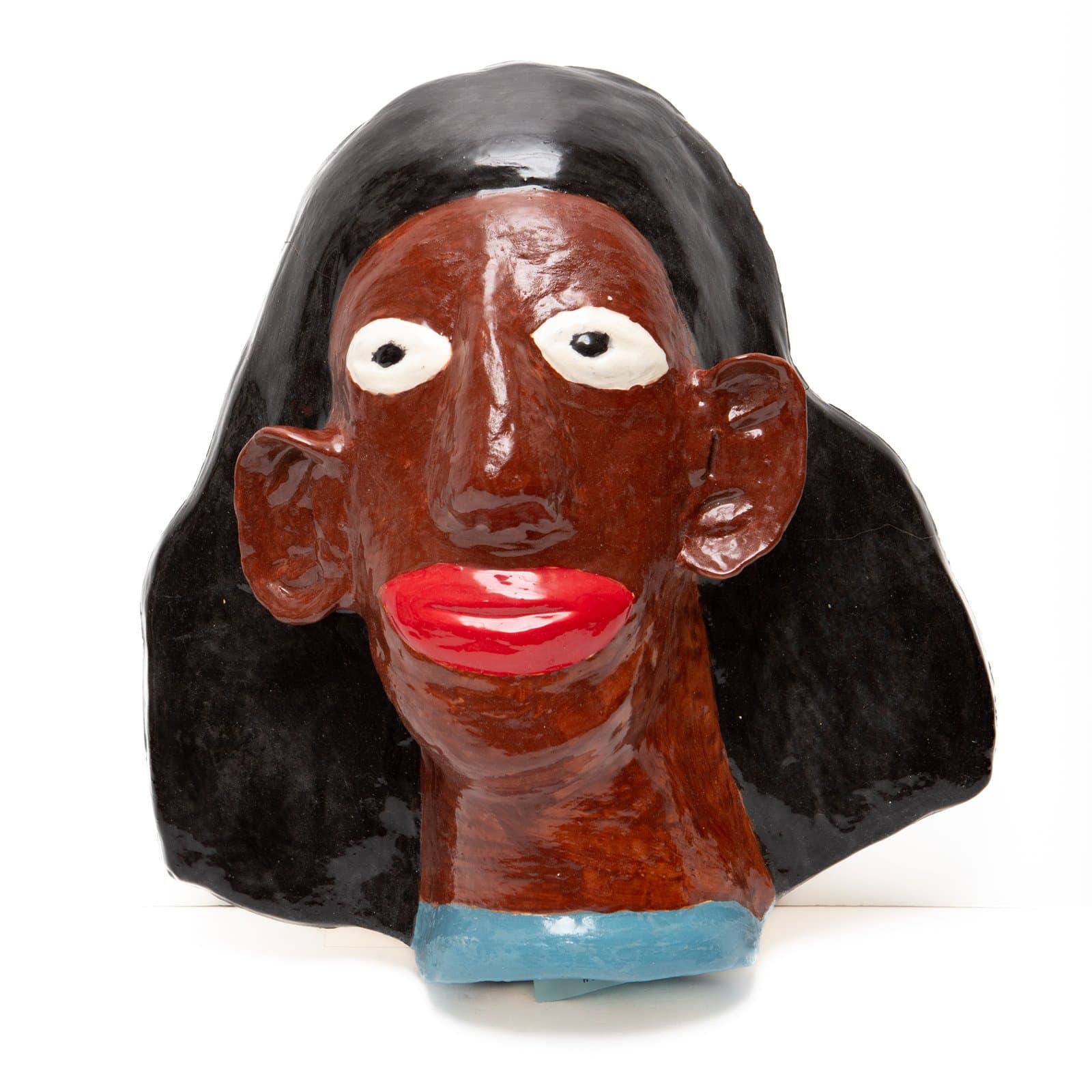 Glazed ceramic bust of a figure with dark brown skin, black hair, white oval eyes, and bold red lips on white background.