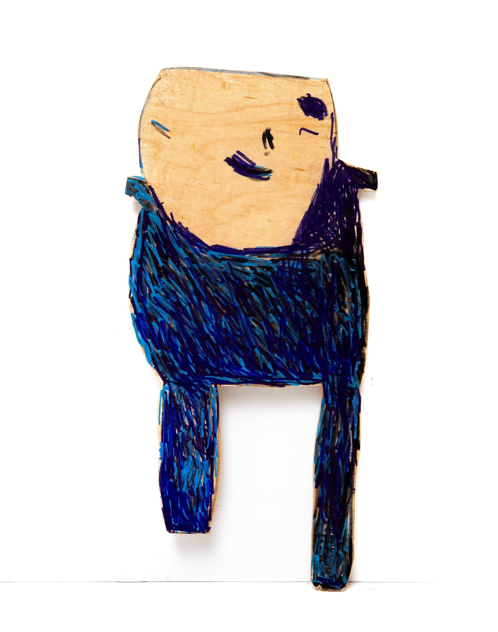 Cutout wood figure of a simplified human form with a bare wood face and body densely covered in blue and purple marker strokes.