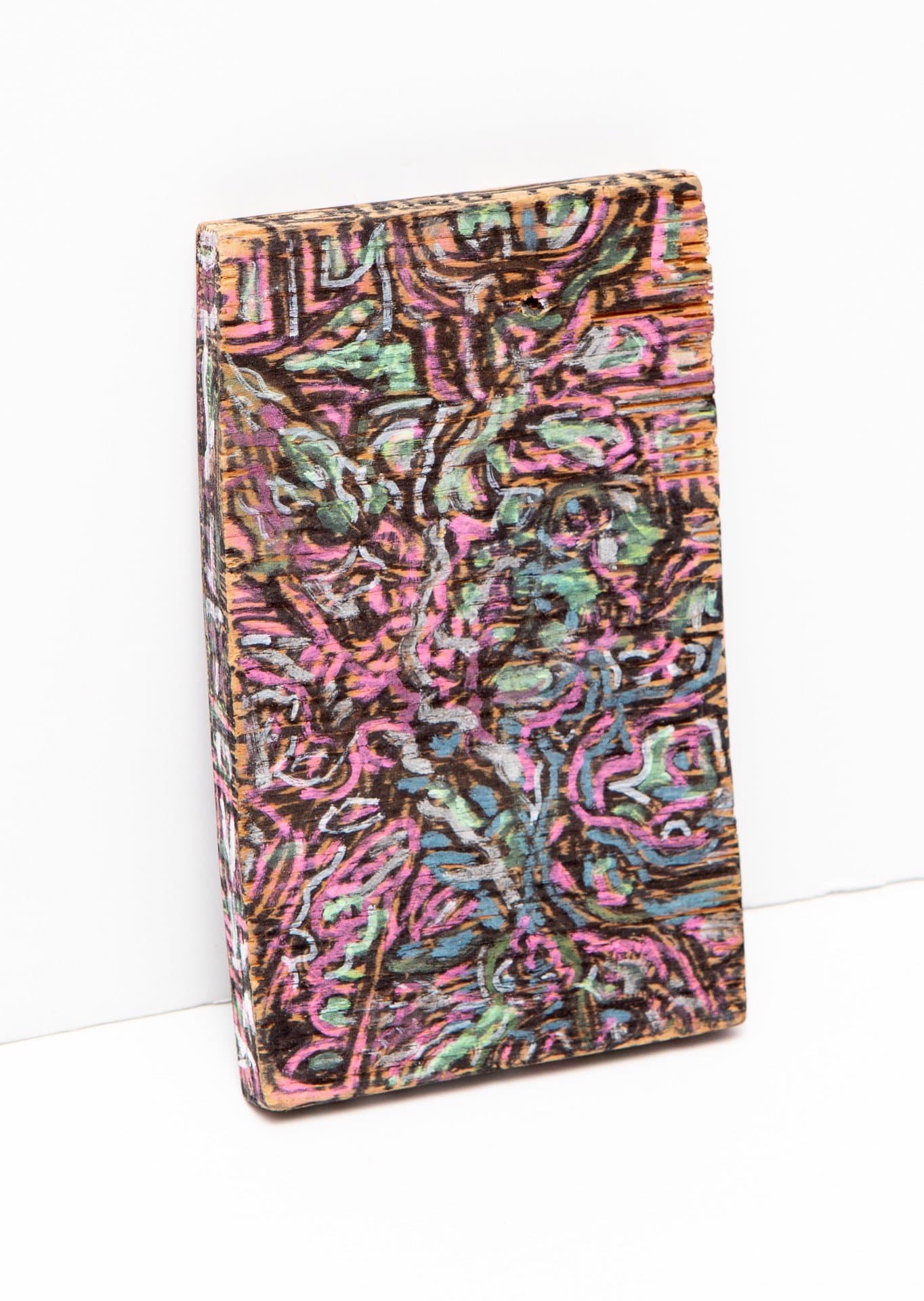 Small rectangular wooden panel covered in dense abstract acrylic painting with swirling forms in pink, green, and brown.