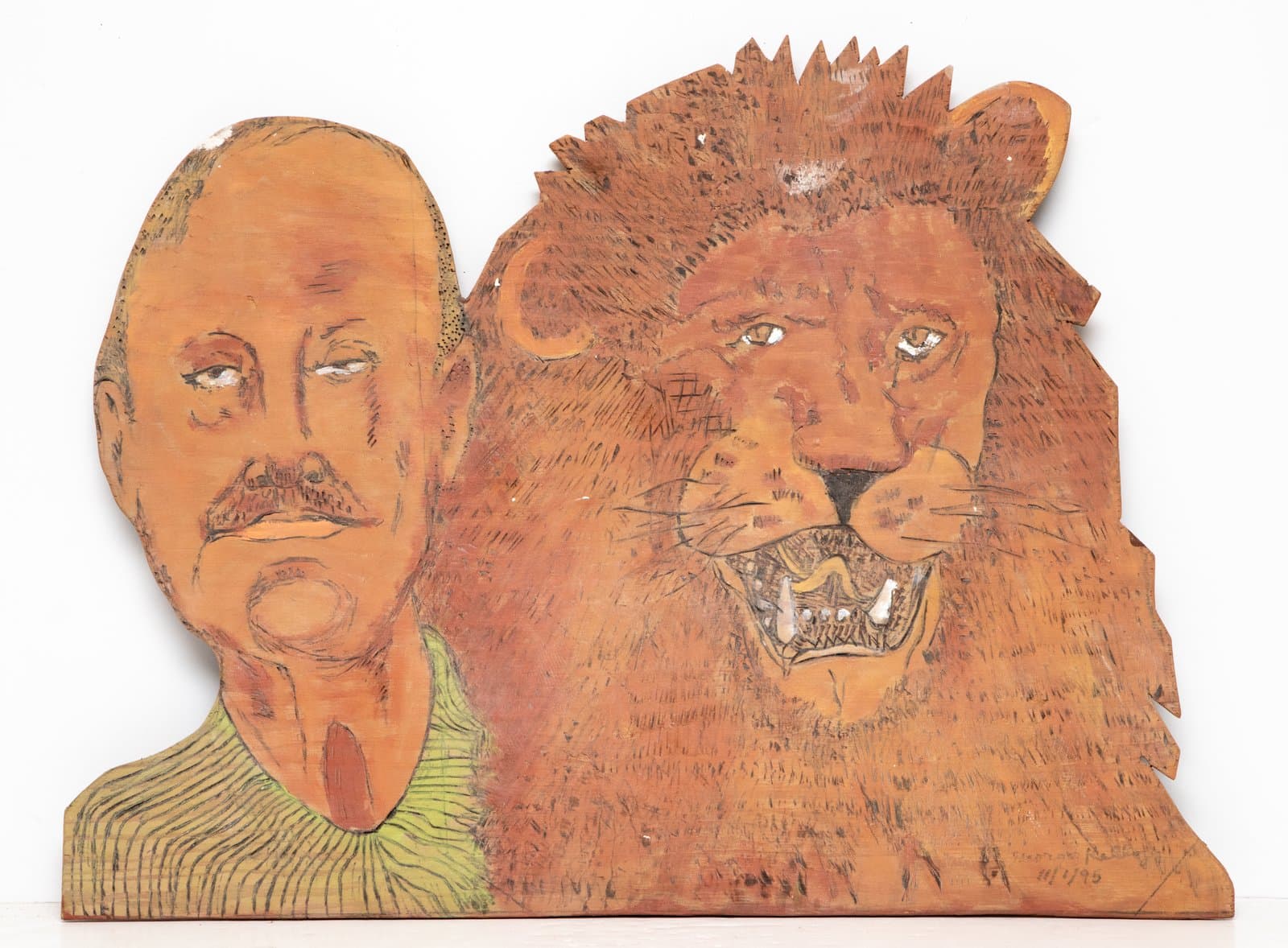 Painted wood cutout depicting a bald man with a mustache beside a roaring lion's head, in warm orange and brown tones.