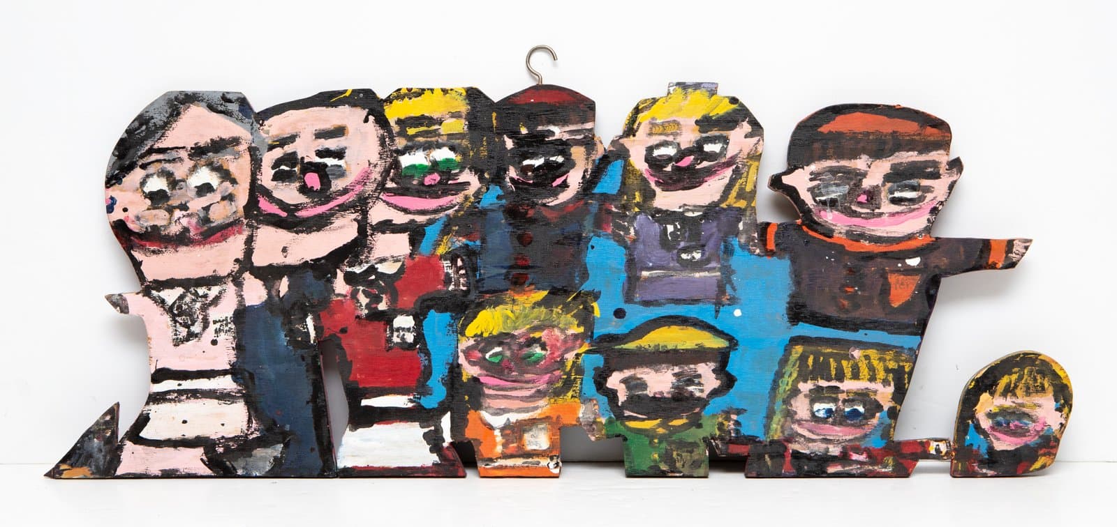 Painted wood cutout sculpture of nine cartoon-style figures in a group, acrylic on wood, multicolored.