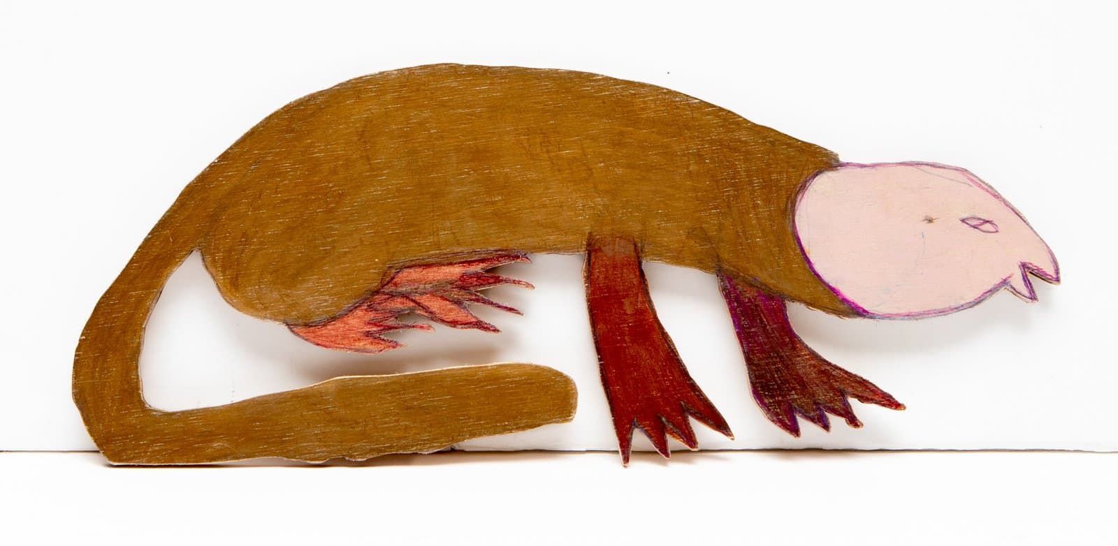 Cut-out wood figure of a crouching monkey-like creature colored in golden brown with a pale pink face and dark red clawed feet.