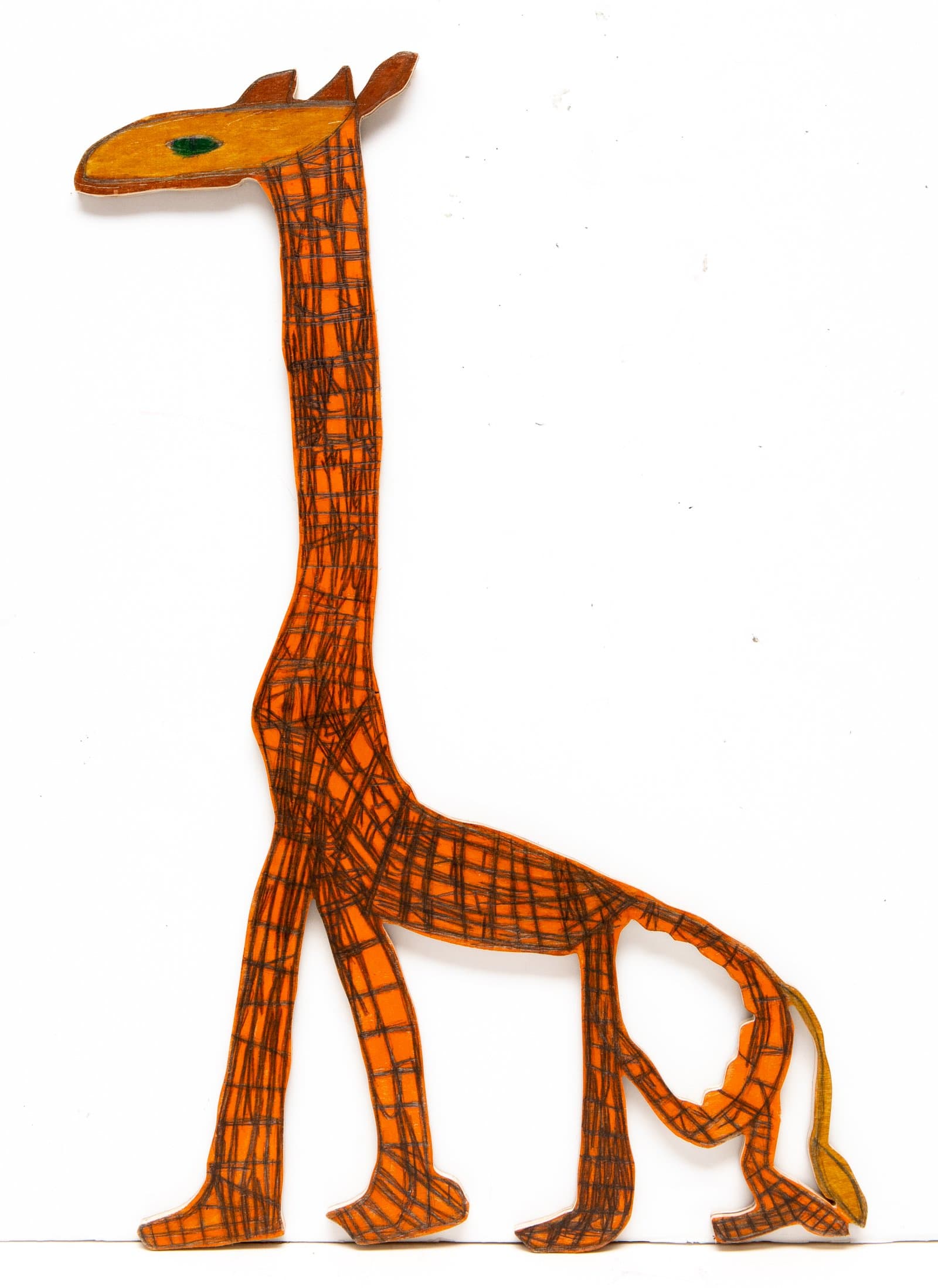 Cut-out wooden giraffe figure painted orange with dark crosshatch grid pattern and a single green eye.