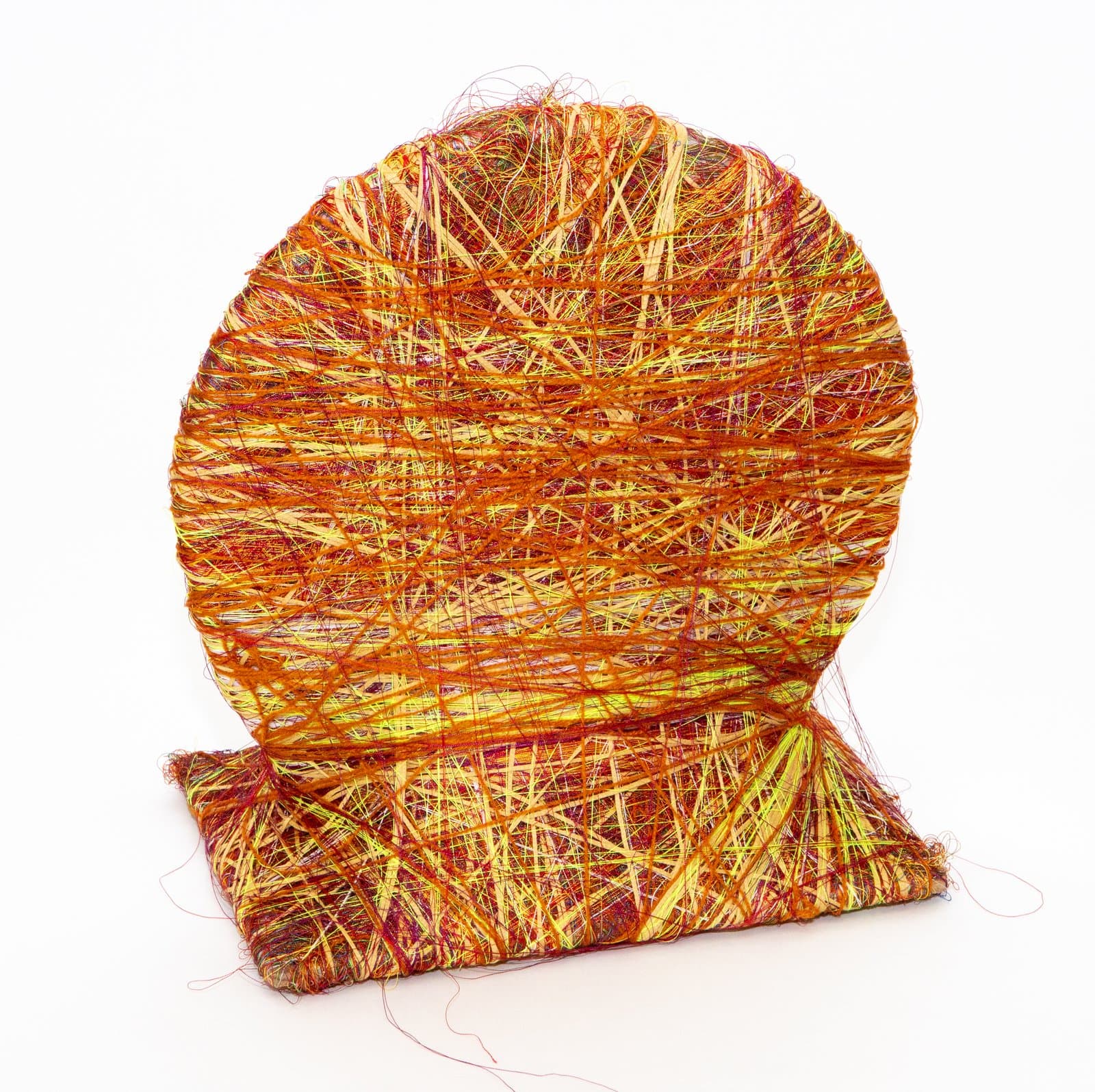 Fiber sculpture of a circular form atop a rectangular base, densely wrapped in orange, yellow, and red thread.