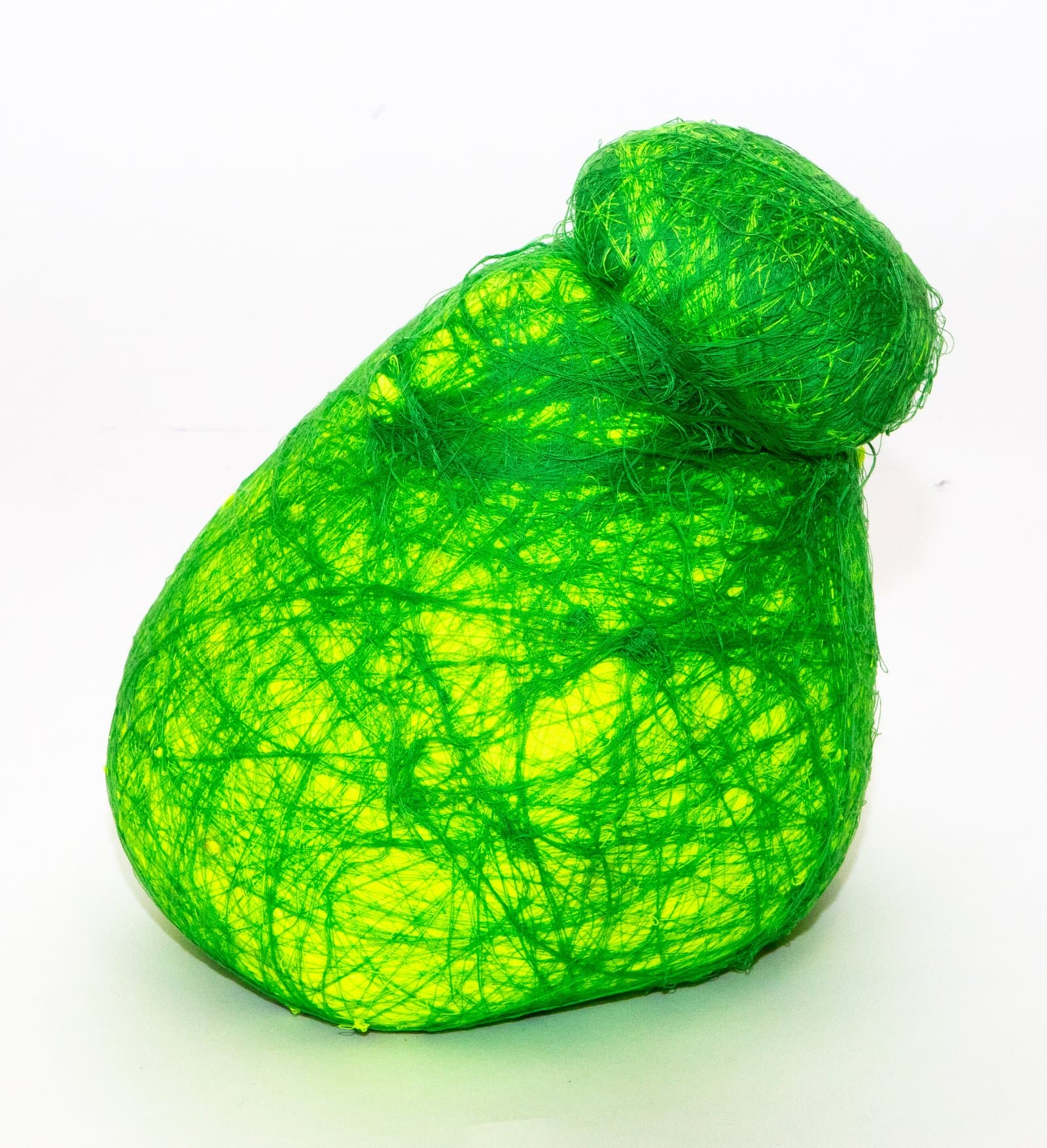 Rounded sculpture wrapped in bright green fiber over a yellow form, with a smaller knob at the top.