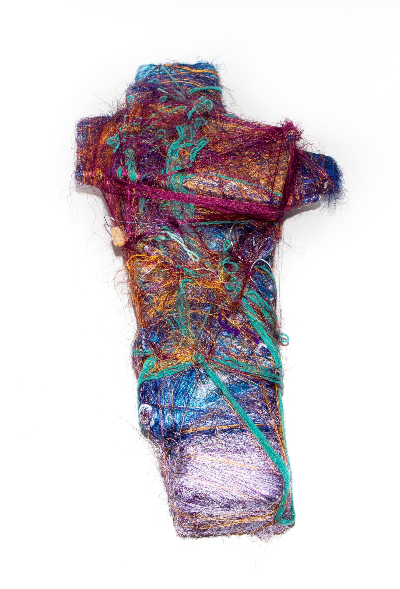 Wrap sculpture of layered, wound fibers in purple, teal, orange, and blue forming a roughly cross-shaped vertical form.