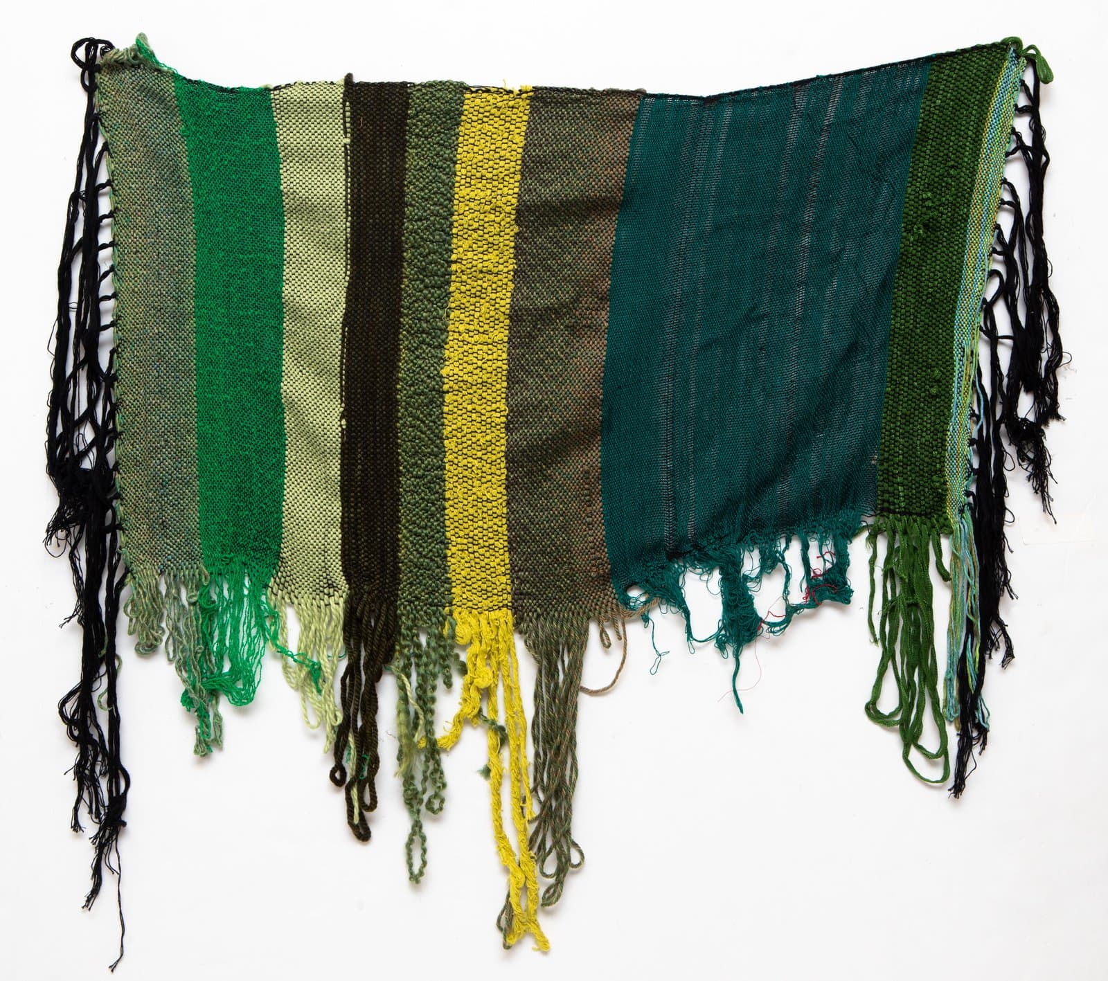 Woven textile with vertical stripes in shades of green, olive, and yellow, with uneven fringe along the bottom and sides.
