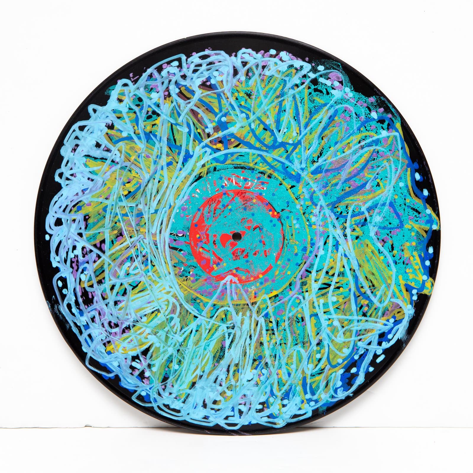 Acrylic painting on a vinyl record with dense looping blue lines radiating from a teal and red center label.