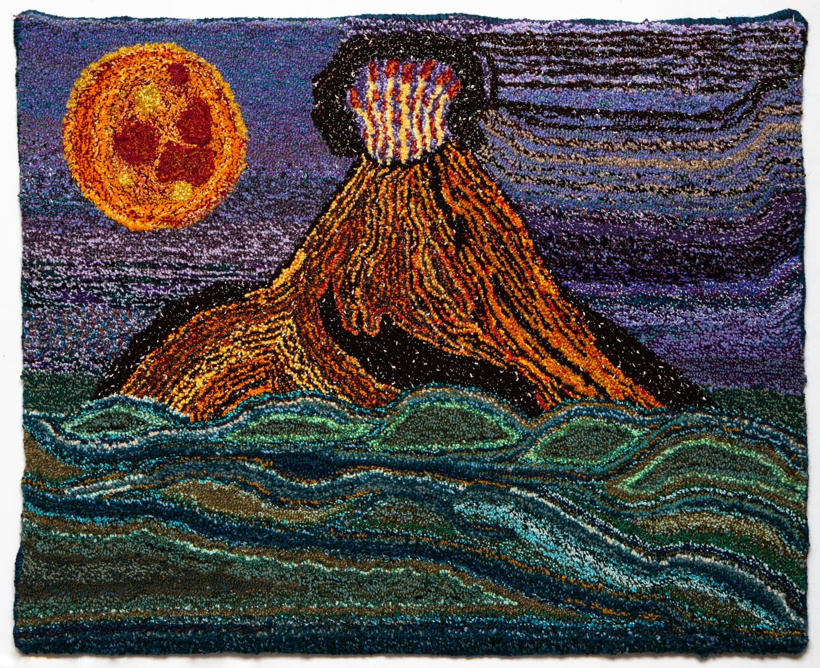 Hooked rug depicting an erupting volcano rising from ocean waves beneath a blood moon in a purple night sky.