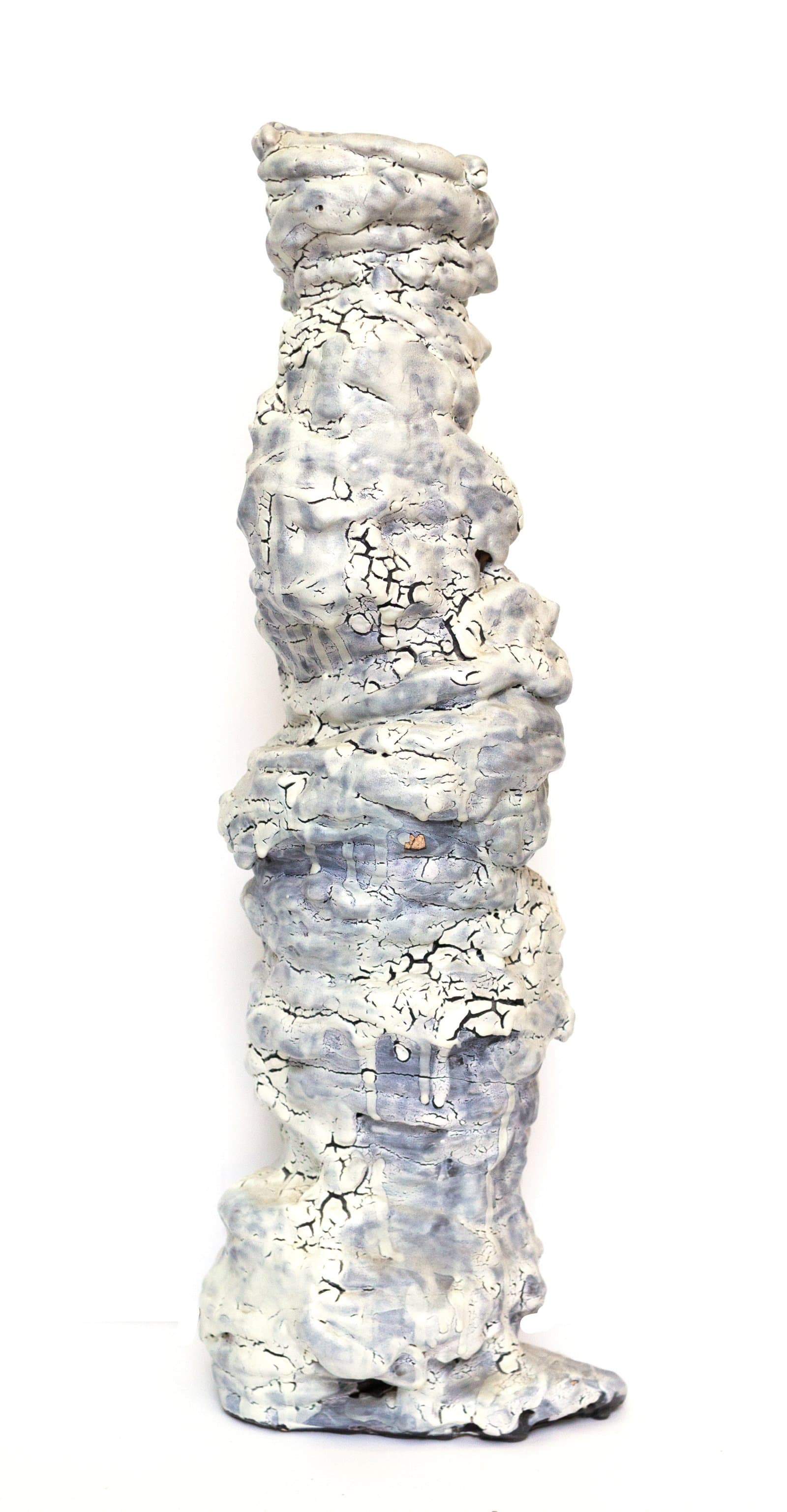 Tall narrow ceramic sculpture with heavily textured, cracked white and pale blue glaze, suggesting a stacked columnar figure.