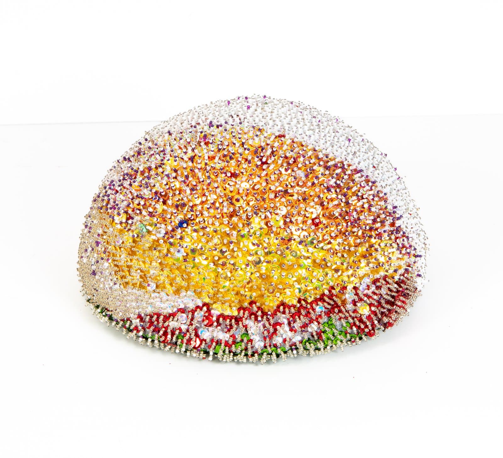 Dome-shaped sculpture covered in beads and sequins radiating from yellow center through orange to silver edges, with red and green base.