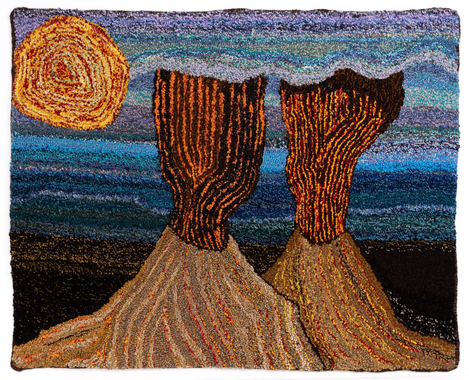 Hooked yarn textile depicting two erupting volcanoes beneath a swirling orange sun against a striped blue sky.