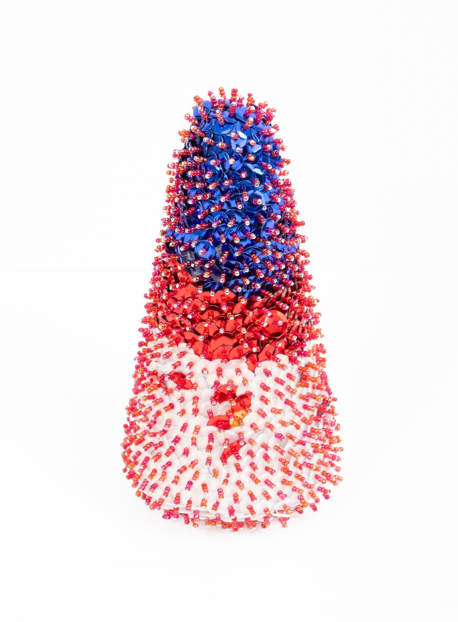 Cone-shaped sequin sculpture densely covered in blue, red, and white sequins with orange and pink beads on white background.