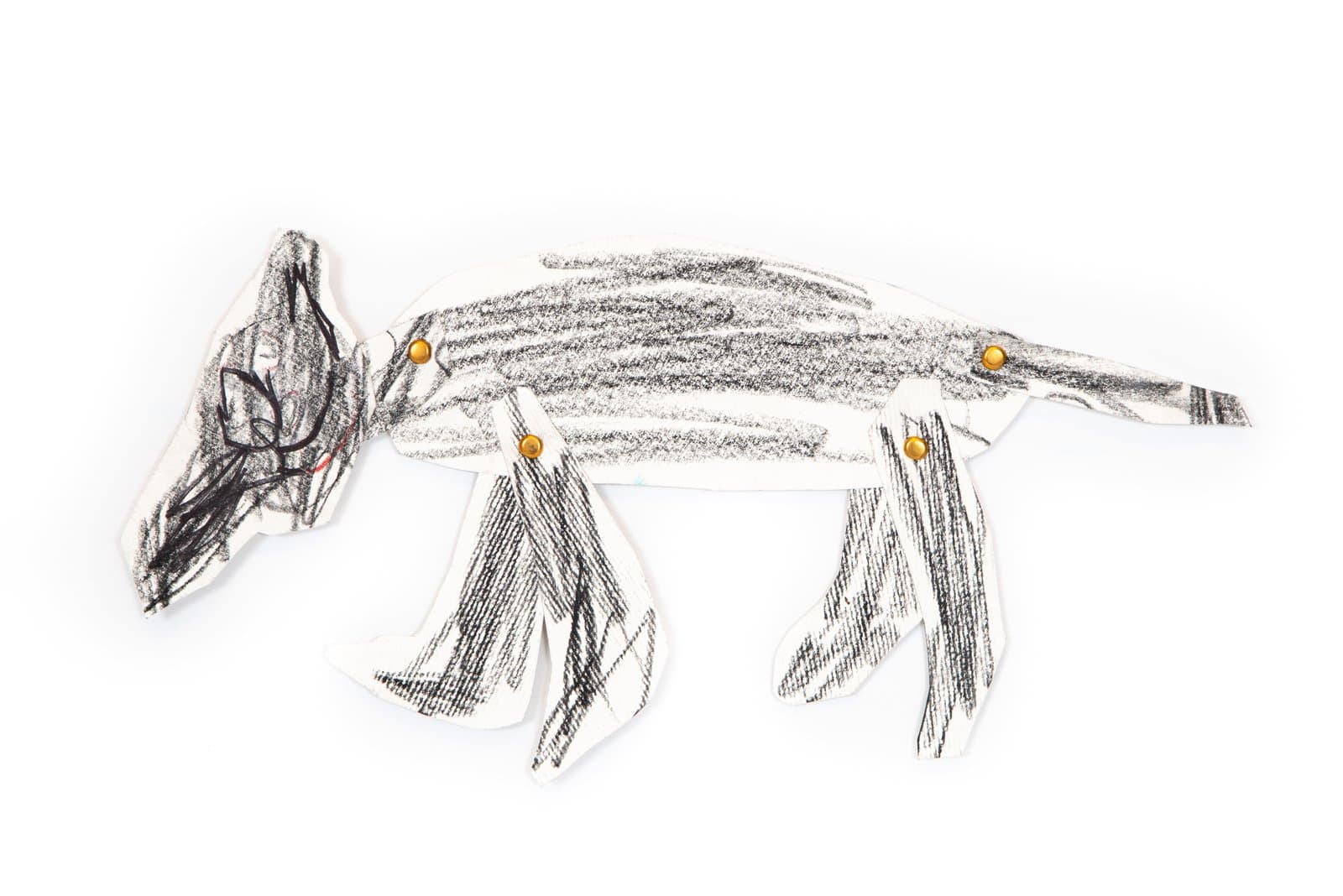 Cut-paper puppet of a four-legged animal drawn in black Art Stix, with gold brad fasteners at the joints.