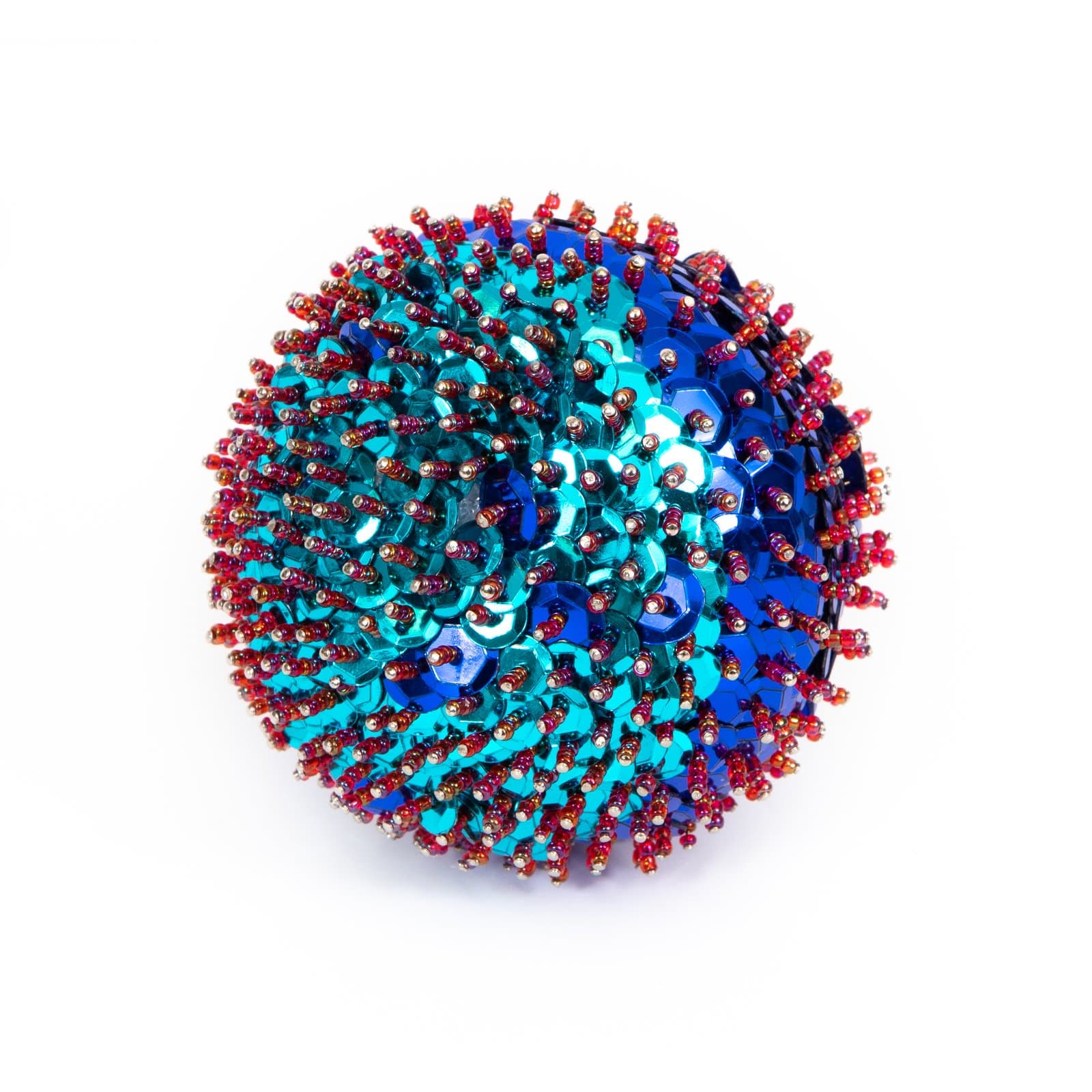 Spherical sculpture densely covered in teal and blue sequins with red, orange, and gold seed beads on pins, on white background.