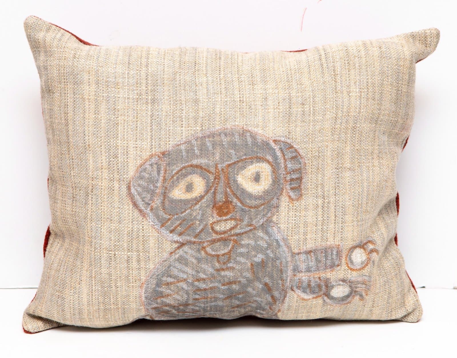 Hand-painted decorative pillow with gray figure featuring large round eyes on natural linen fabric with red trim.