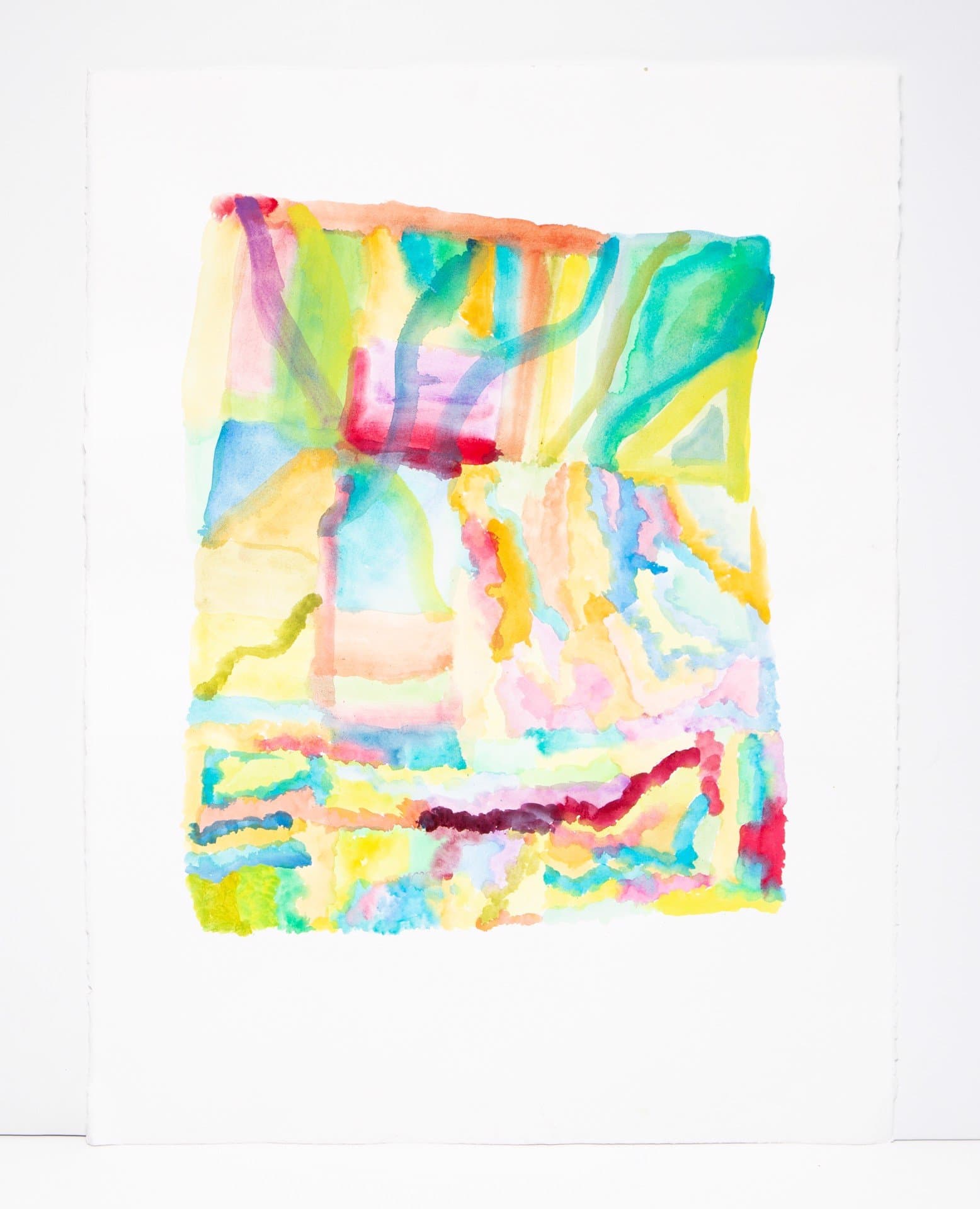 Abstract watercolor painting with vibrant washes of blue, green, yellow, pink, and orange in loose geometric forms on white paper.