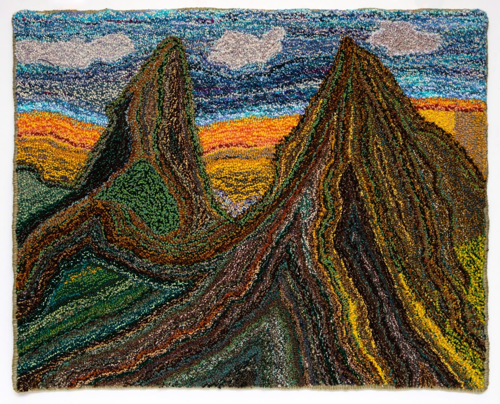 Colored pencil landscape drawing depicting mountainous terrain with dense, layered strokes in earth tones and blues.
