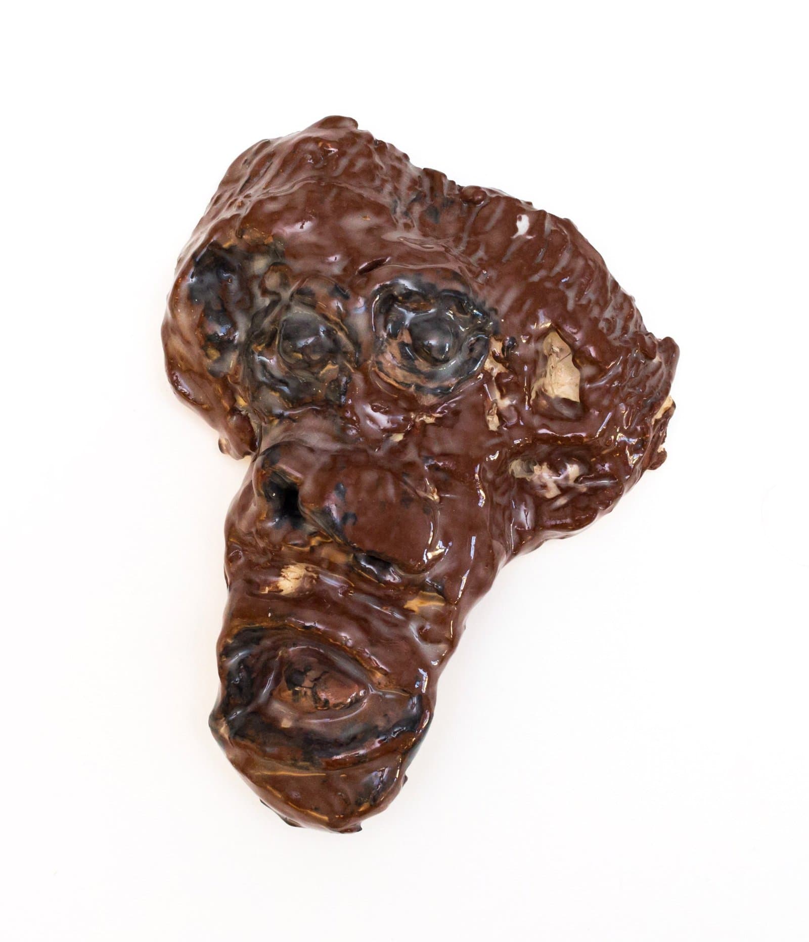 Sculptural artwork resembling a human head profile in glossy brown ceramic with textured, organic surface