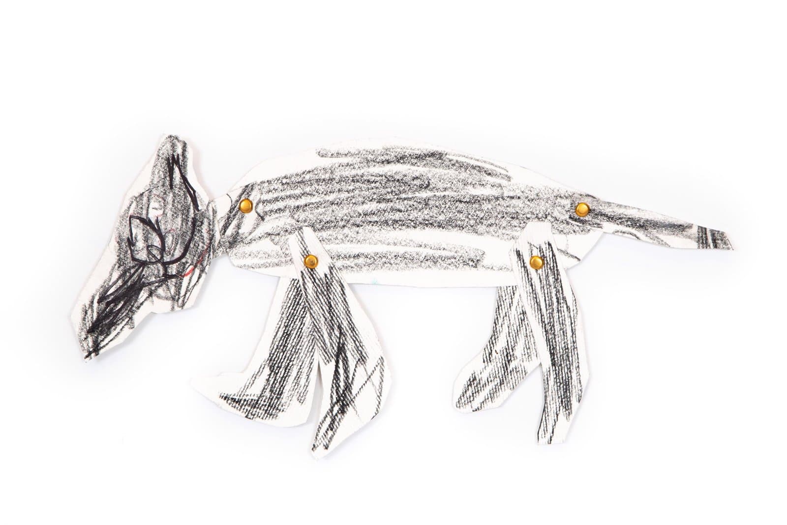 Paper puppet drawing of a quadruped animal in black art stix with orange circular details on white paper.