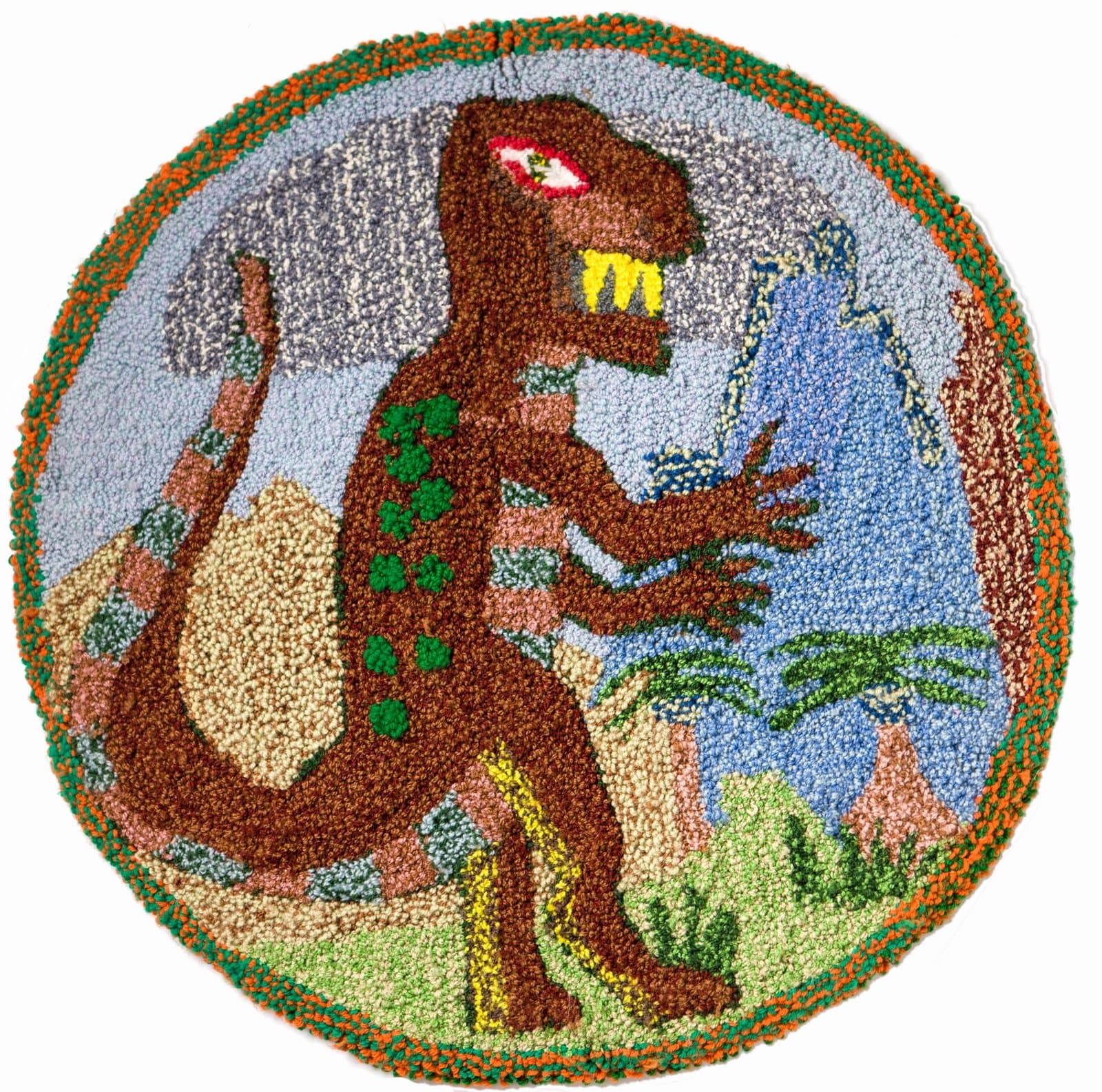 Circular hooked rug depicting brown dinosaur with yellow teeth in landscape with blue sky and green vegetation.