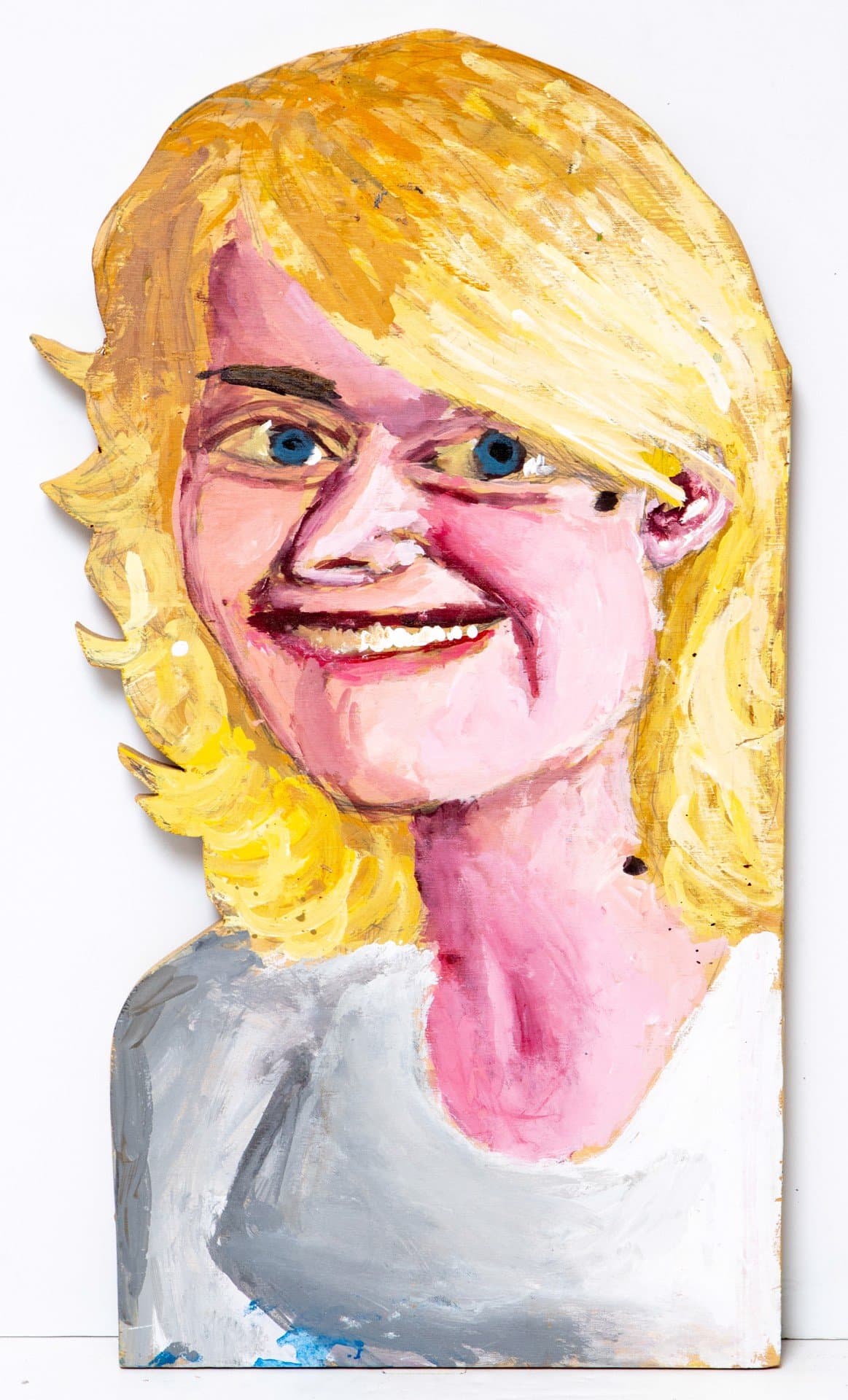 Portrait sculpture in acrylic on wood depicting a smiling figure with blonde hair and blue eyes
