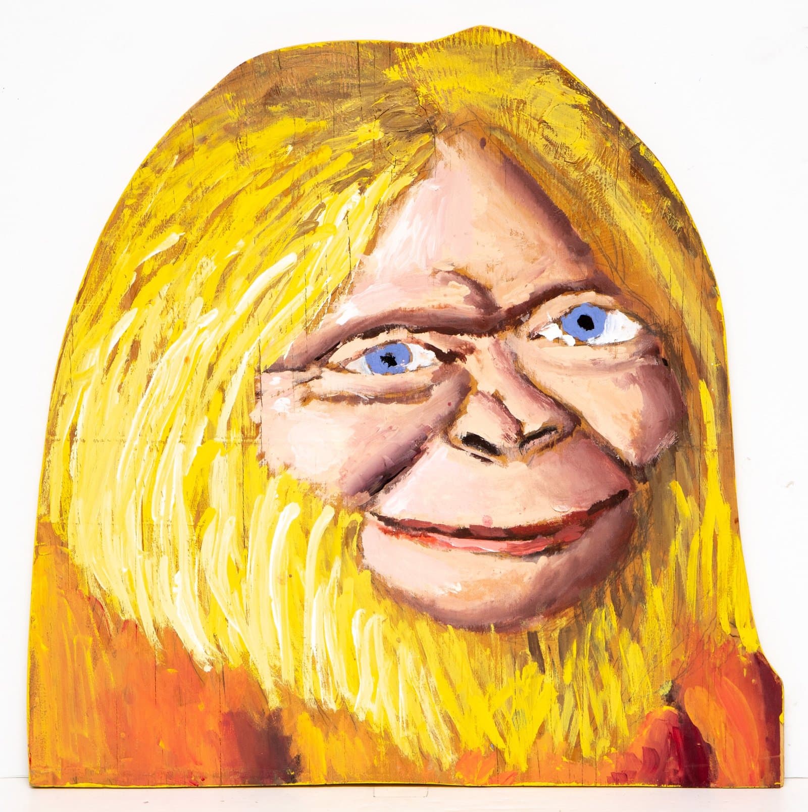 Acrylic on wood sculpture of a face with bright yellow hair and blue eyes, painted in expressive brushstrokes