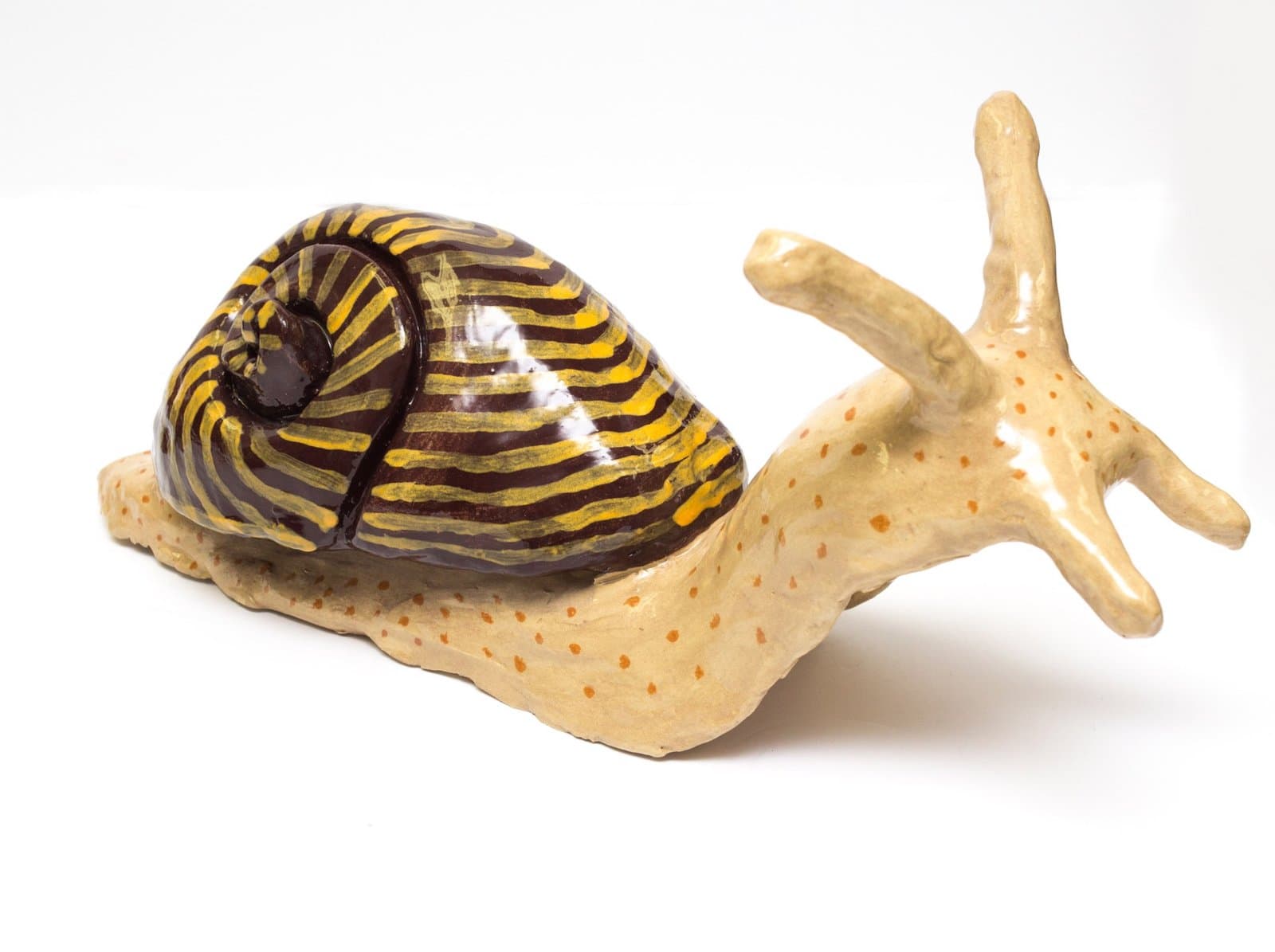 Ceramic sculpture of a snail with golden striped shell and cream-colored body with orange spots