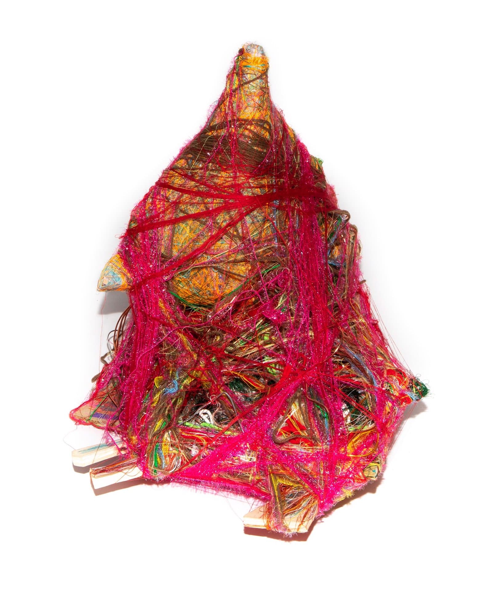 Mixed media wrap sculpture with vibrant pink yarn wound around colorful paper and fabric materials in cone shape.