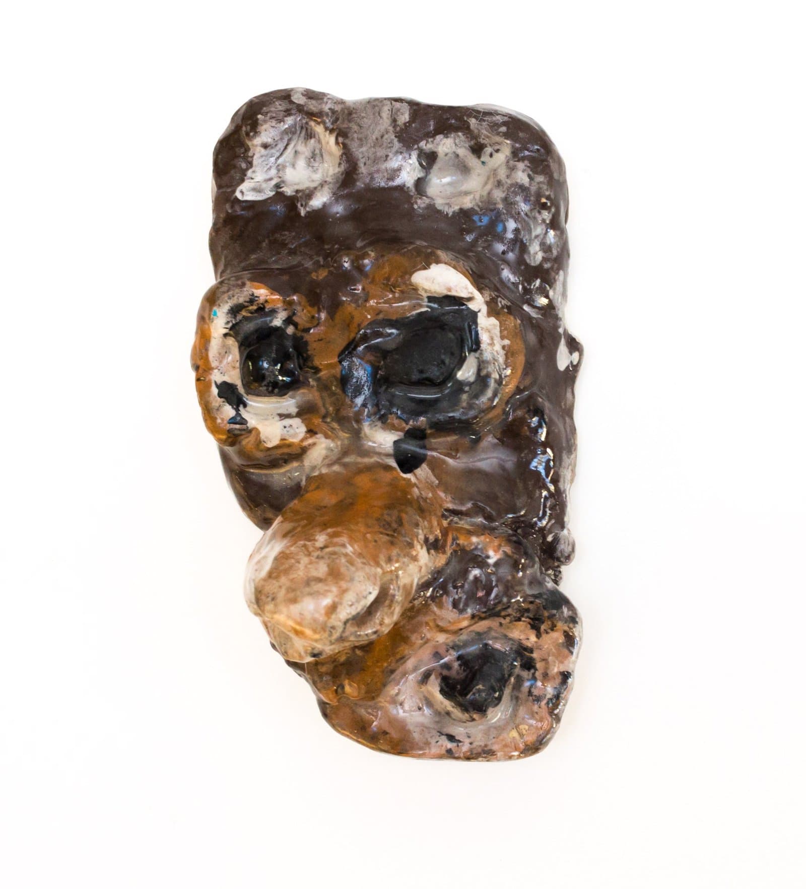 Ceramic sculpture with irregular form featuring hollow openings and mottled brown, black, and cream glazed surface