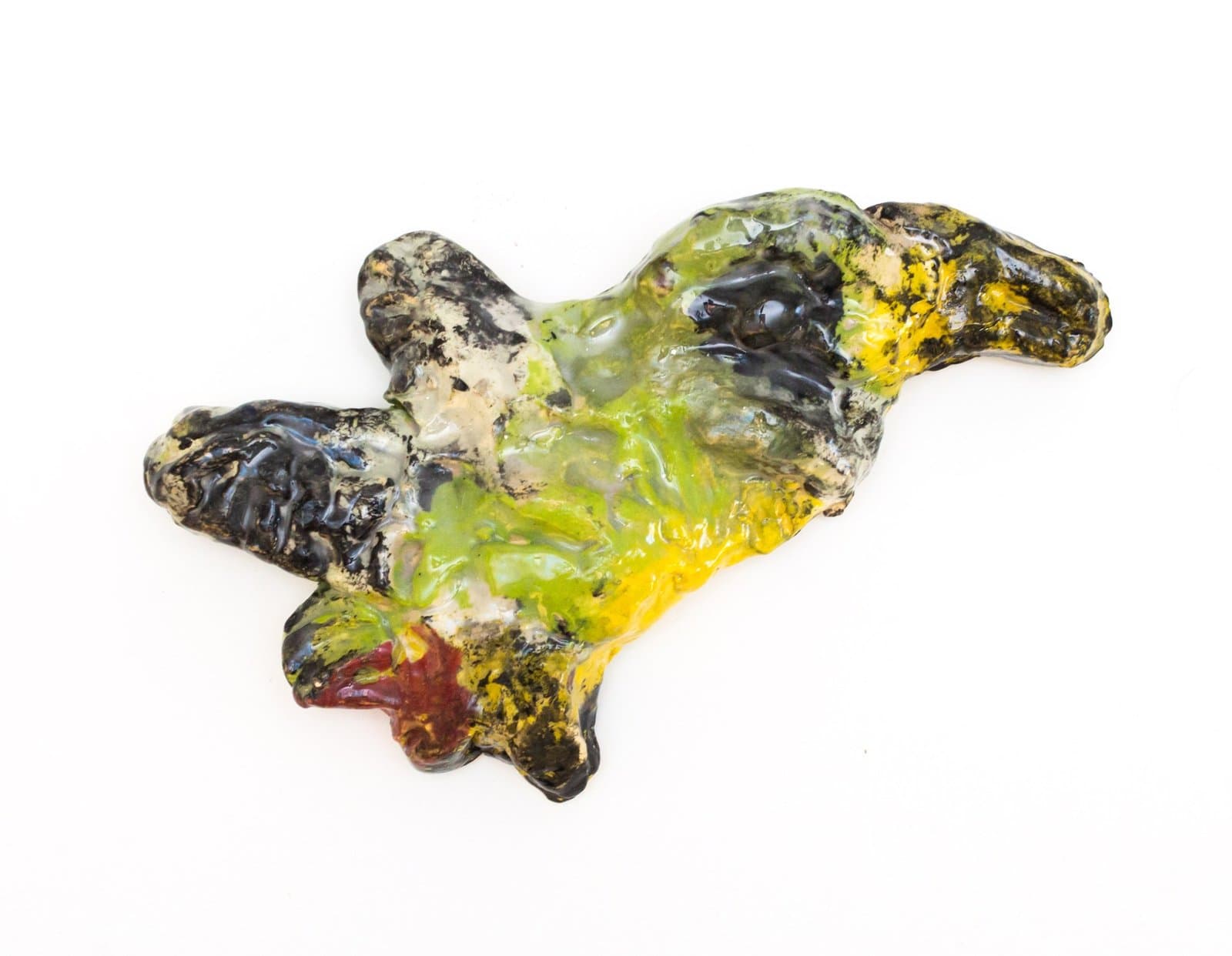 Abstract sculptural form in glazed ceramic with flowing organic shape in green, yellow, black, and white