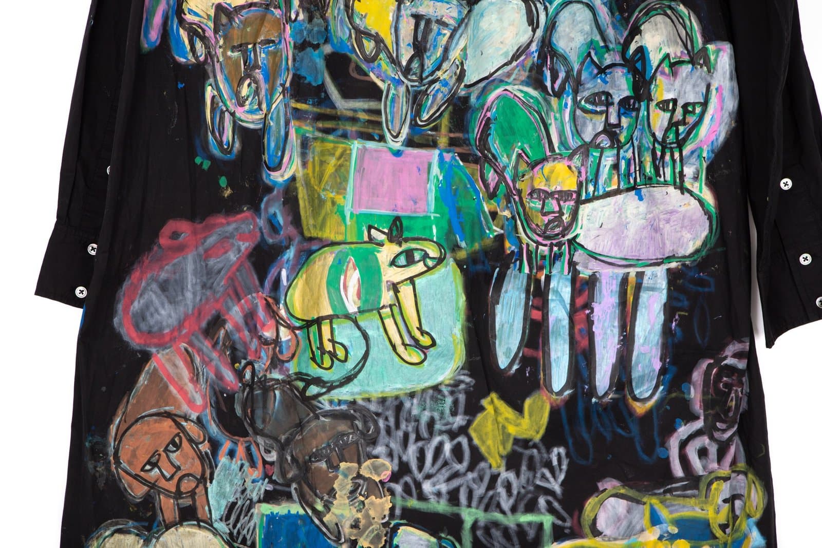 Mixed media artwork on black t-shirt featuring colorful figurative drawings with faces, animals, and abstract forms