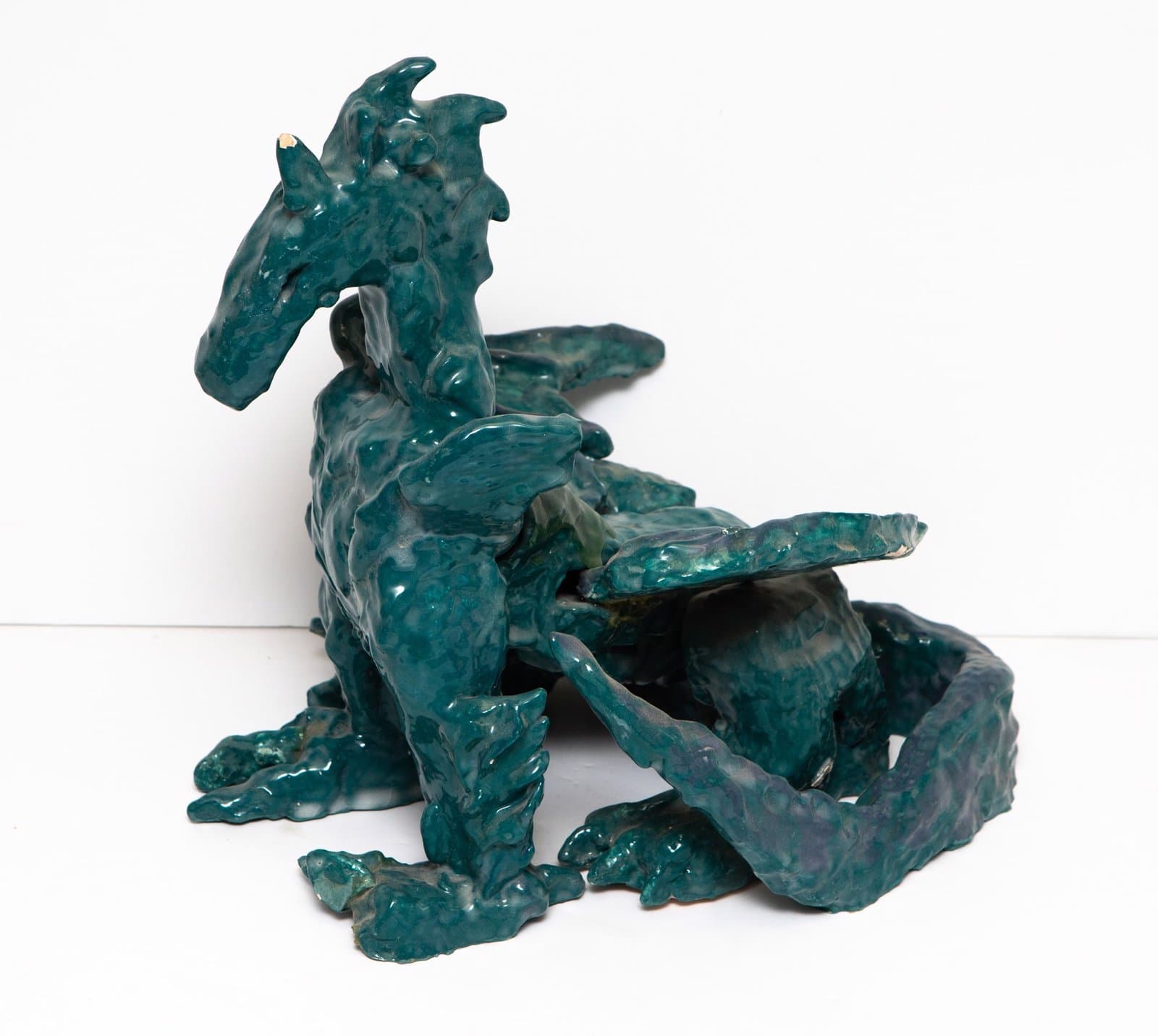 Abstract ceramic sculpture with flowing, organic forms in teal and dark green glazes on white background.